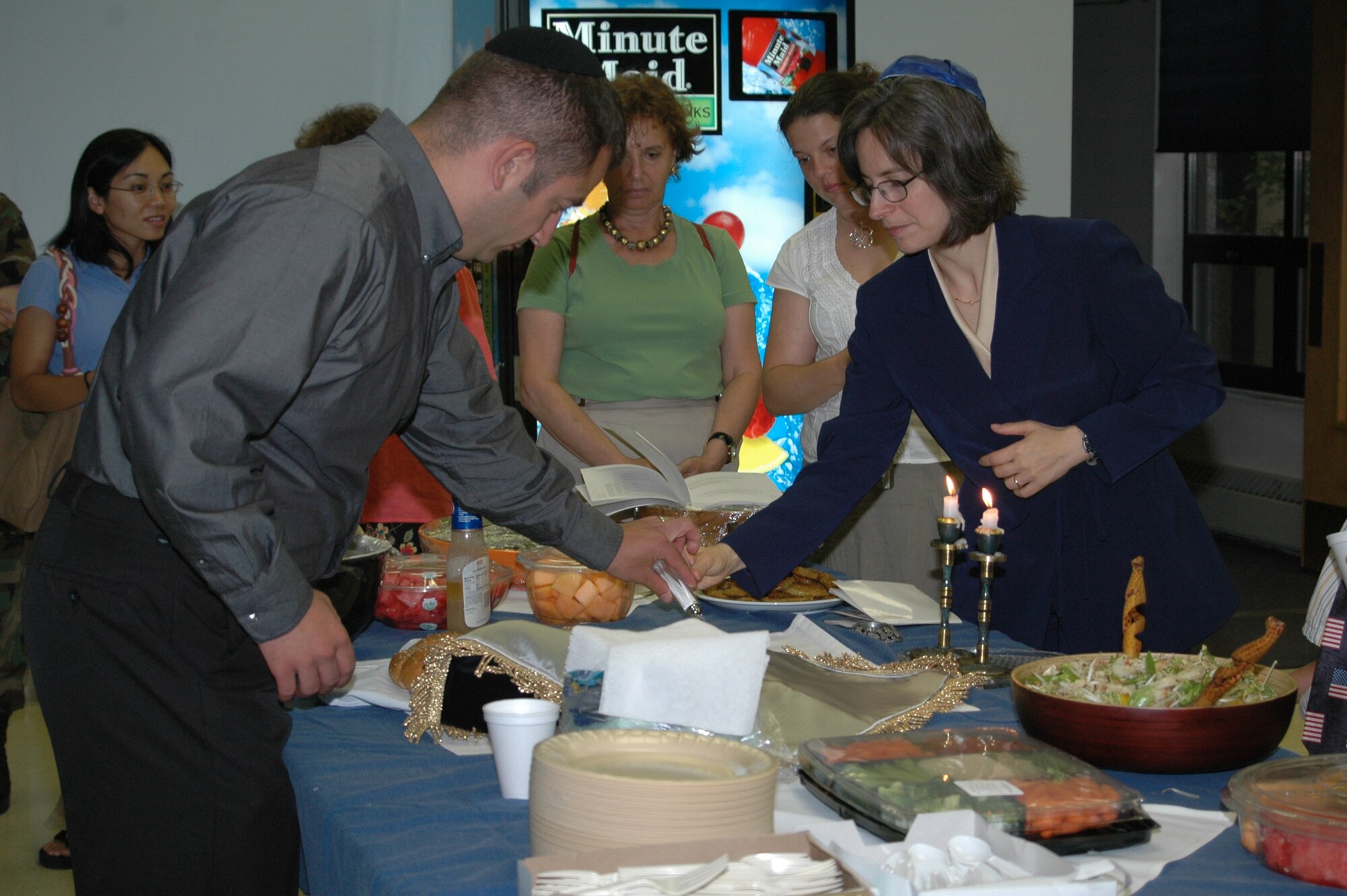 First Lieutenant Maxwell Bassman, 10th Missile Squadron, helps Rabbi (Capt.) Sarah Schechter prepare for a meal at the chapel Friday following a Jewish service during her visit to Malmstrom July 6 to 9. Rabbi Schechter is the only female Rabbi in the Air Force. She held a number of Jewish activities during her visit, including Torah studies, dinner at the chapel and a luncheon at the Grizzly Bend Club. (U.S. Air Force photo / Airman 1st Class Emerald Ralston)