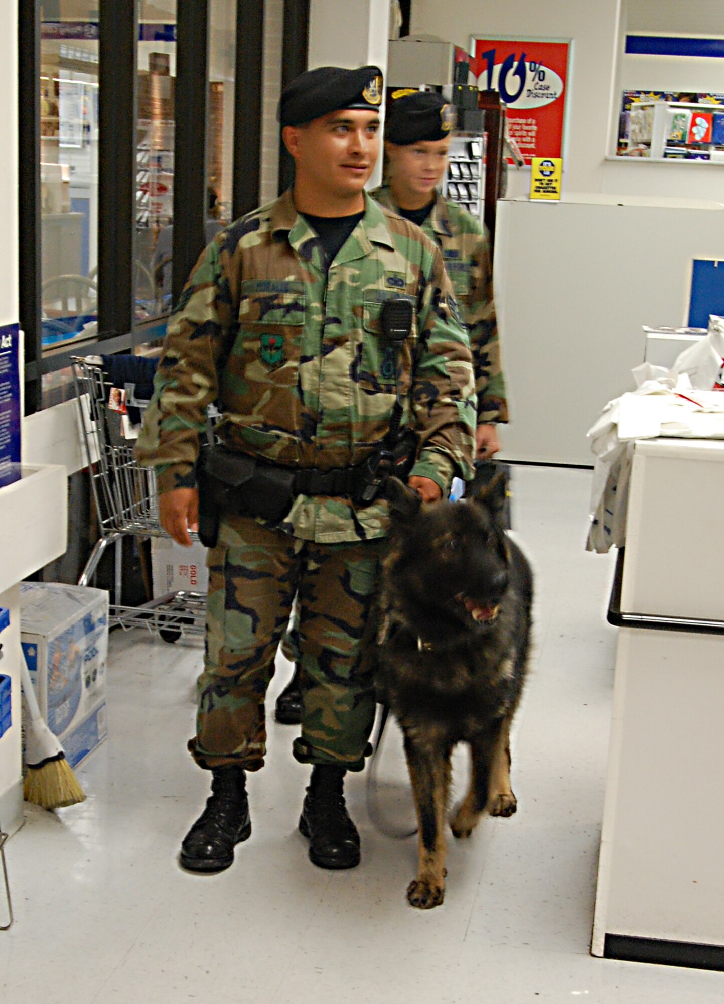 LAUGHLIN AIR FORCE BASE, Texas -- Staff Sgt. Eric Morales, 47th Security Forces Squadron, and Staff Sgt. Julie Hurt, 47th SFS, take Kelly, working military dog, around the Base Exchange before Maj. Gen. Dawran take a tour of the facility. (U.S. Air Force photo by Airman Sara Csurilla)