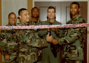 Col. Mark Barrett, 1st Fighter Wing commander, along with 1st FW Airmen, cuts the ribbon during the reopening of the Bayside Enlisted Club July 13. The $4.9 million repair project began after Hurricane Isabel stormed through Langley Sept. 18, 2003. (U.S. Air Force Photo/Senior Airman Tabitha Kuykendall)