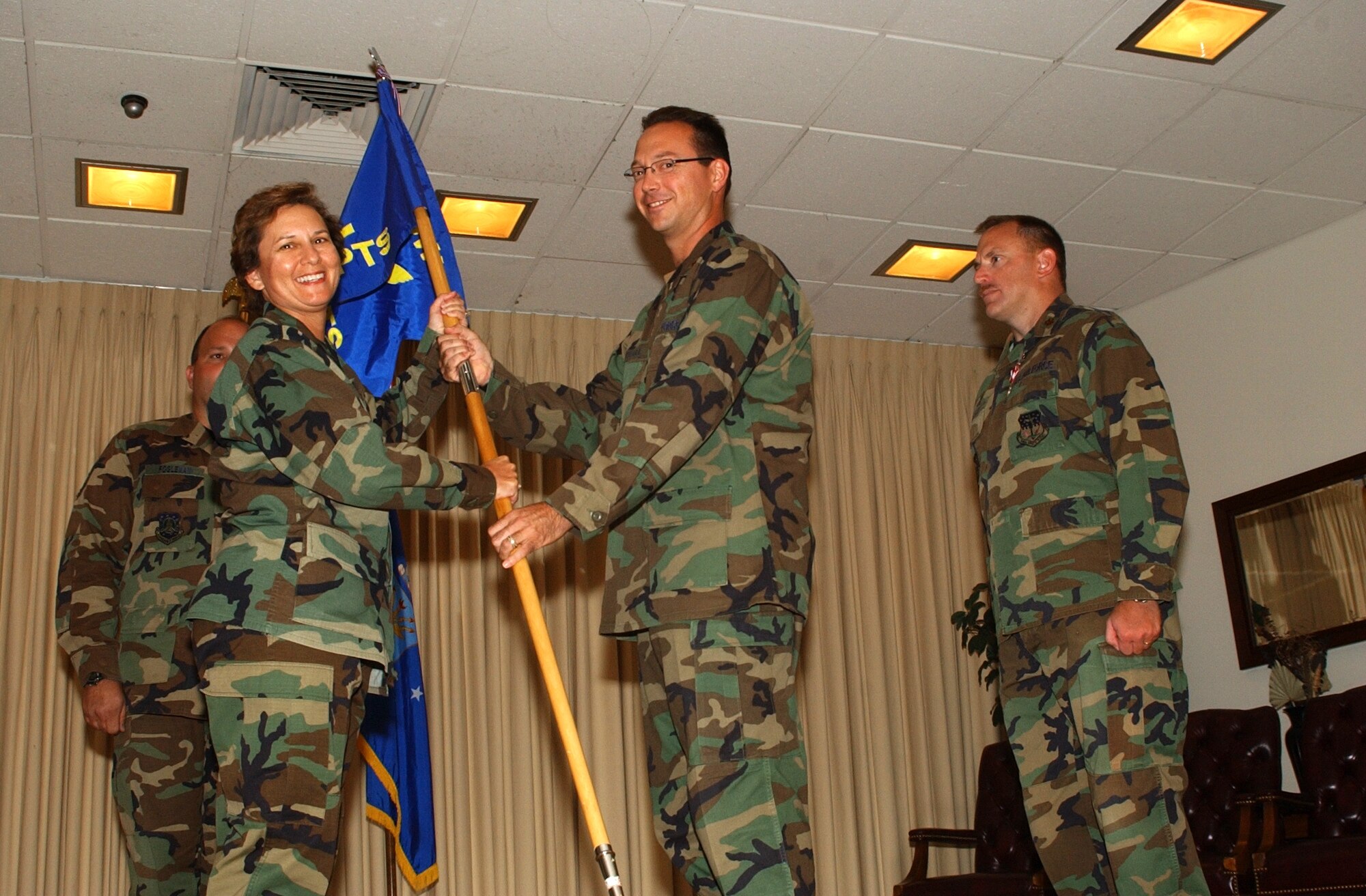 Maj. Trevor Whitehall accepts the guidon for the 341st Comptroller Squadron from Col. Sandy Finan, 341st Space Wing commander, during a change of command ceremony Tuesday at the Grizzly Bend Club. Outgoing 341st CPTS commander, Maj. Brent Hatch, looks on. (U.S. Air Force photo / Airman 1st Class Dillon White)