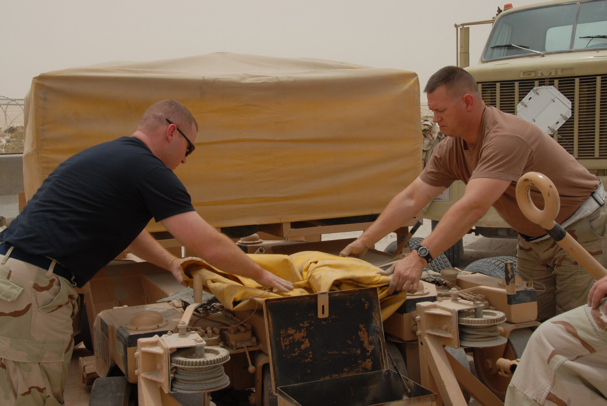 Master Sgt. Alridge Allsman (left) and Tech. Sgt. Gregory Nichols fold the main landing gear wheel skate cover. Wheel skates are portable devices that, when installed, take the place of landing gear. (U.S. Air Force photo)