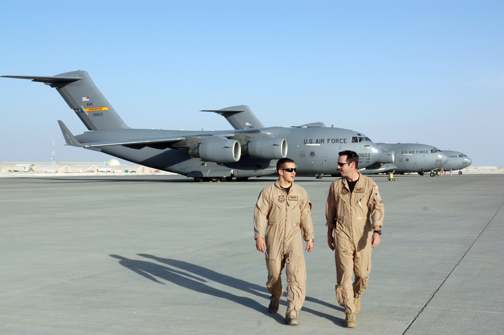 Capt. Corbett Bufton, 816th Expeditionary Airlift Squadron C-17 aircraft commander (right), walks with Senior Airman David Methvan, 816th EAS loadmaster, on the flightline here. The crew of the C-17 flight to save Soldiers in Iraq, otherwise known as the “RED 7” included, Captains Bufton, Scott Frescette and Justin Herbst, Staff Sgt. Matt Nemeth, Senior Airman David Methvin and Lt. Col. Jesse Strickland, all based out of Charleston Air Force Base, S.C.(U.S. Air Force photo by Capt. Teresa Sullivan)