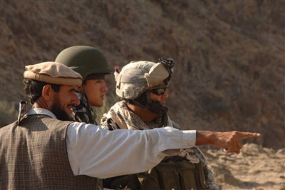 U.S. Army Staff Sgt. Daniel Moncada (right) listens as an Afghan local and his interpreter discuss road activity at an observation post outside of Forward Operating Base Kalagush in the Nuristan province of Afghanistan on June 19, 2007.  Moncada is attached to Charlie Company, 1st Battalion, 158th Infantry Regiment, Arizona Army National Guard.  