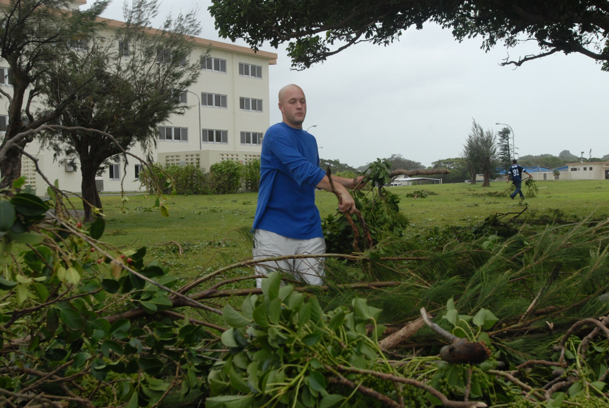 Senior Airman Matthew Amerson piles tree branches outside his dormitory at Kadena Air Base, Japan, July 14. The branches were knocked down by Typhoon Man-Yi which brought the base 77 mph winds gusting to 105 mph.  There were no injuries or significant damages to base structures.  The typhoon was the strongest to hit the base since 2003.  Airman Amerson is assigned to the 18th Logistics Readiness Squadron.  (U.S. Air Force photo/Senior Airman Darnell T. Cannady) 