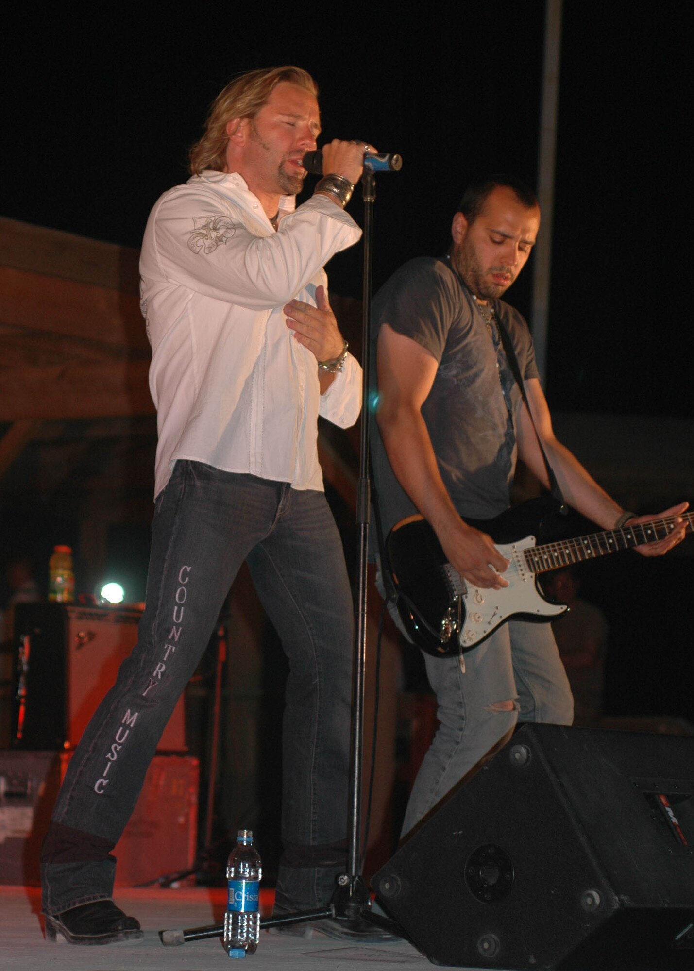 Country music artist Brian Stace (left) and lead guitarist Mark Agnessi (right) performs for U.S. Servicemembers at Kandahar Air Field, Afghanistan July 7. Stace and his band played at several bases in Afghanistan during a three week tour. (Army photo by Sgt. Tony J. Spain)