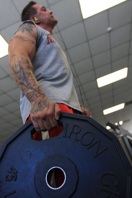 Pvt. Matthew Dejiacomo, a mechanic with Company A, 3rd Light Armored Reconnaissance Battalion, lifts 45 pounds of iron as he builds muscle during a routine workout at the East Fitness Center and Gym Nov. 3. The East Gym is hosting the Winter Weight Loss Challenge this year to help Combat Center personnel maintain their weight during the holidays.