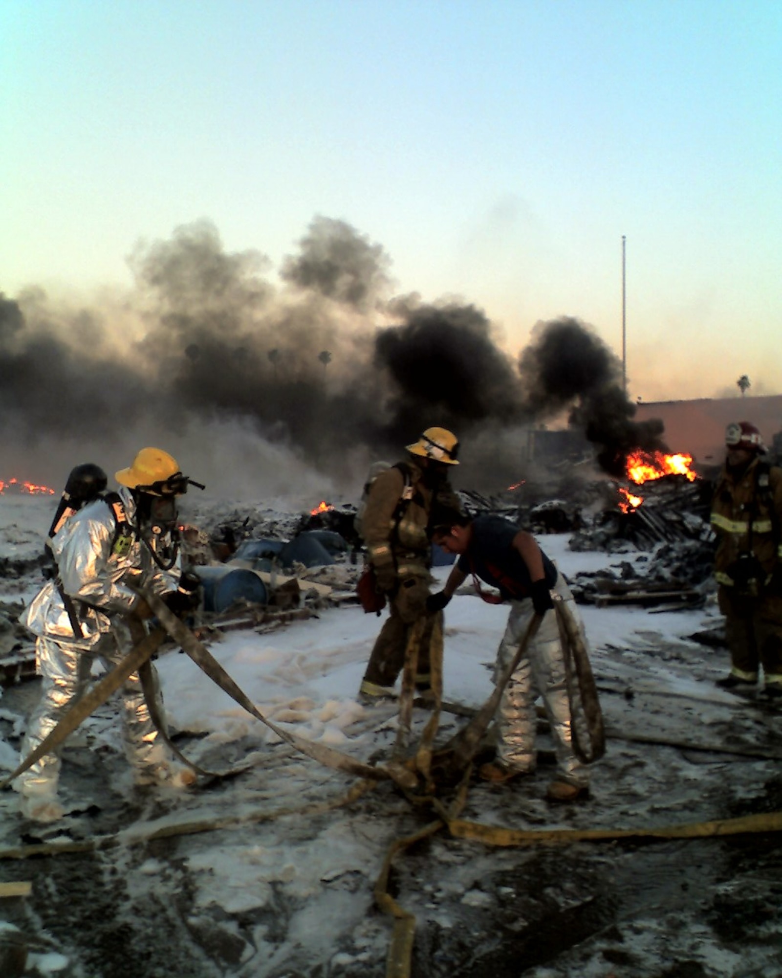 Several March Air Reserve Base firefighters move hoses after containing the fire. (U.S. Air Force photo by Chris Christianson)