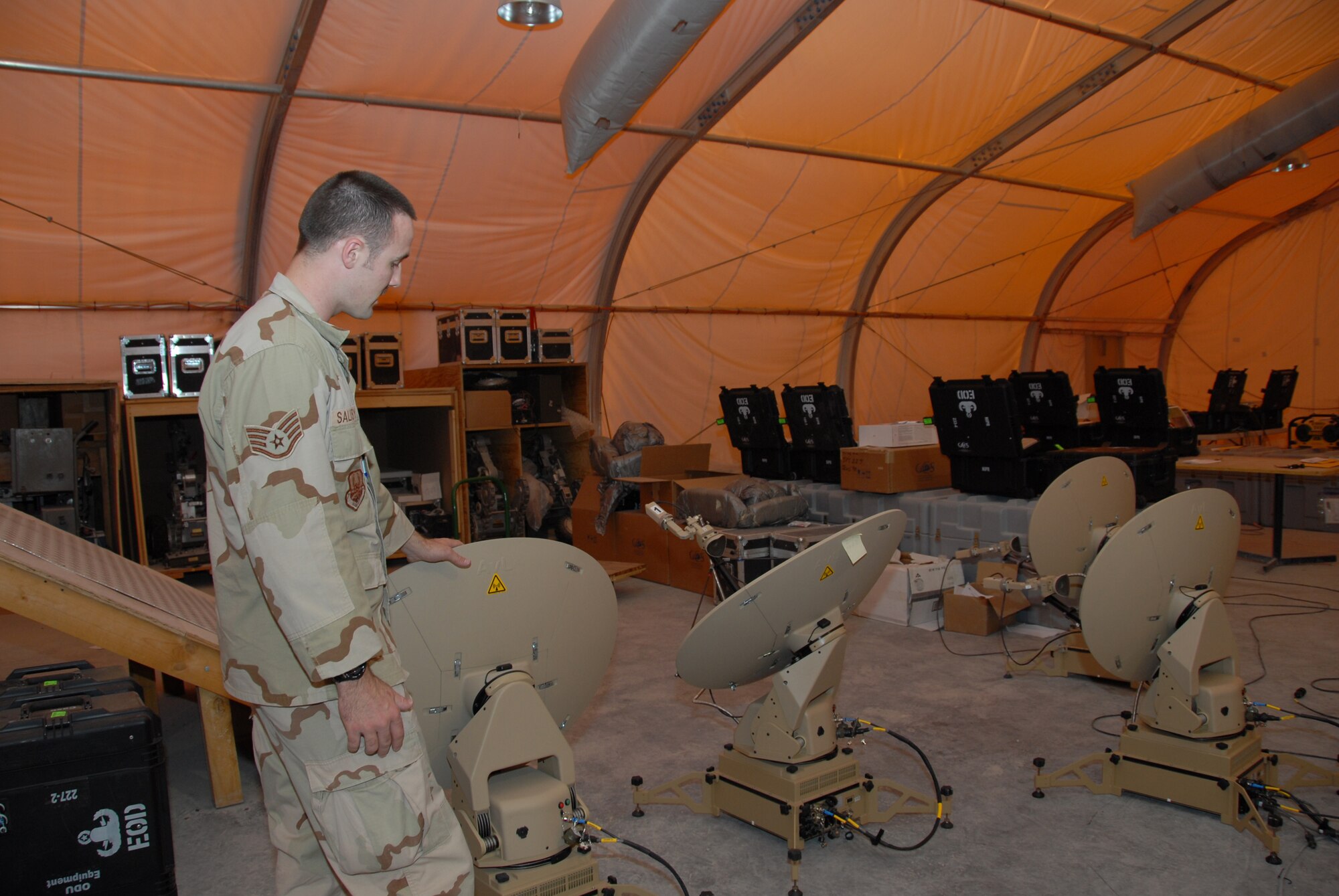 Staff Sgt. Jonathan Salisbury, 379th Expeditionary Civil Engineer Squadron Explosive Ordnance Disposal, inspects Very Small Aperture Terminal satellite dishes that will be sent to forward-deployed EOD teams in the AOR.  (U.S. Air Force photo by Airman 1st Class Ashley Tyler)