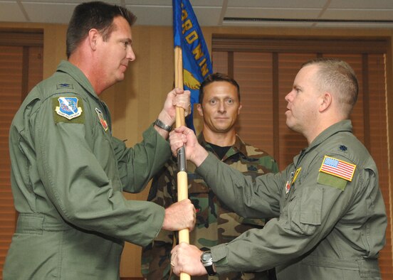 Lt. Col. Denis P. Doty (right) receives the 563rd Operations Support Squadron guidon from 563rd Rescue Group Commander Col. Lee K. DePalo during a change-of-command ceremony at the Mirage Officer's Club here July 13. Colonel Doty, who has accumulated more than 3,800 flying hours, assumed command after serving as chief of safety for the 23rd Wing at Moody Air Force Base, Ga. (U.S. Air Force photo/Airman 1st Class Noah R. Johnson)