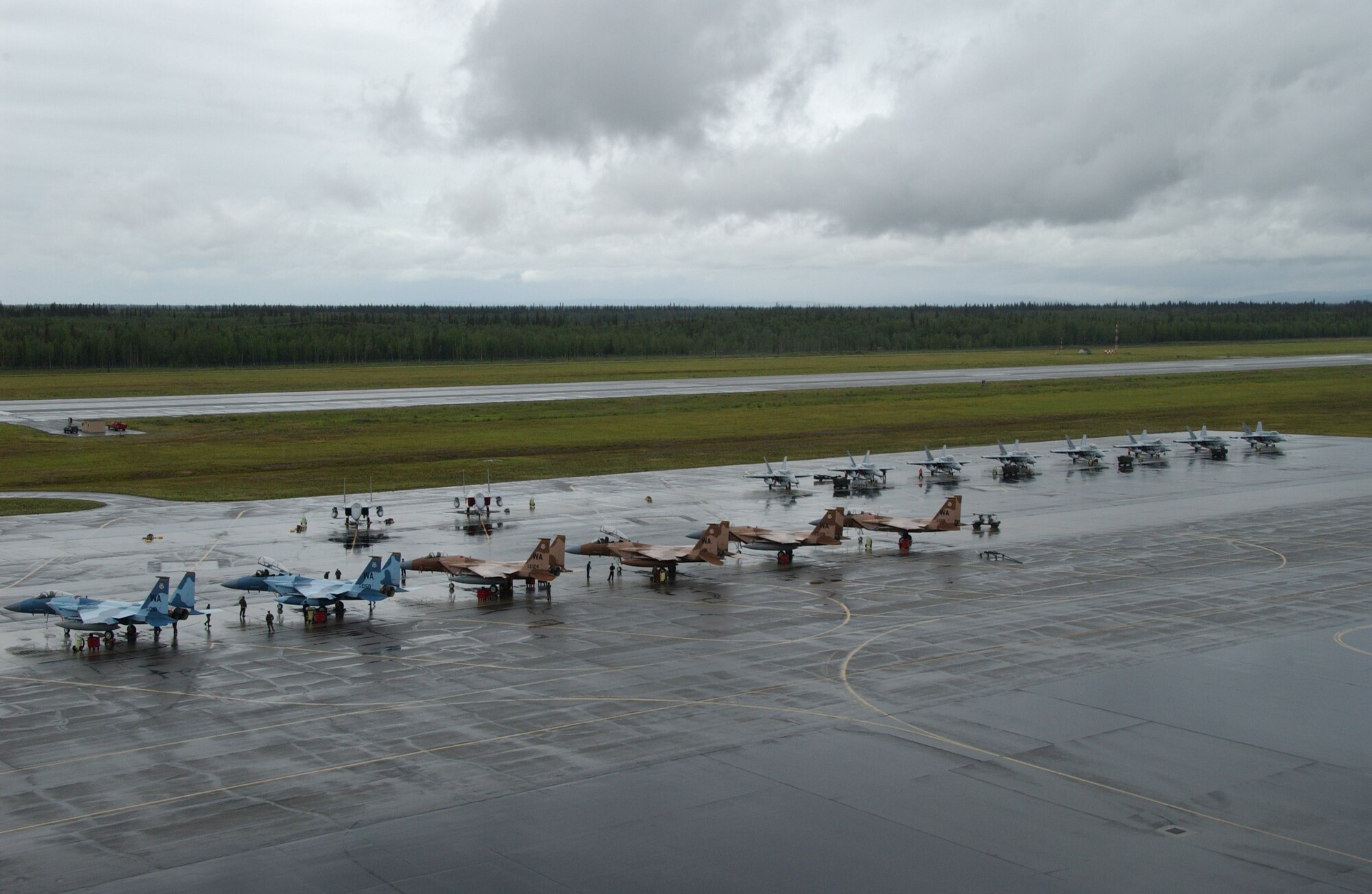 EIELSON AIR FORCE BASE, Alaska -- F-15C Aggressors from Nellis AFB, Nev., and Spanish Air Force F-18's sit parked on the flight line awaiting the official start to Red Flag-Alaska July 11, 2007. This exercise provides unique opportunities to help integrate various forces into joint, coalition, and bilateral training from simulated forward operating bases. (U.S. Air Force photo by Airman 1st Class Christopher Griffin)