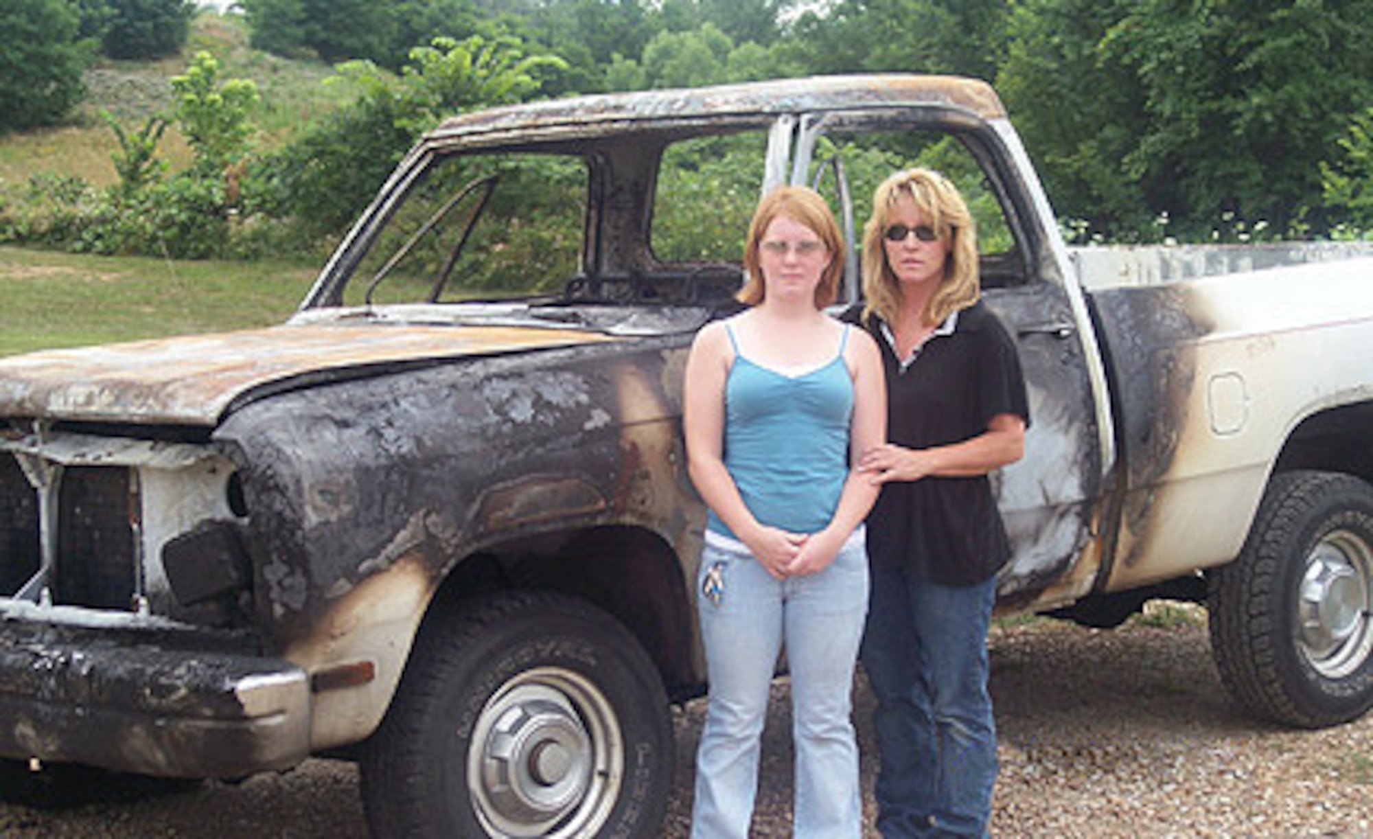 Brooklynn and Susan Wagner stand in front of the burned remains of the 1992 Dodge Ram truck, which belonged to Tech. Sgt. Joe Clark, 509th Aircraft Maintenance Squadron. The two escaped the truck blaze unharmed June 25 in Knob Noster, Mo. (Photo printed with permission of Susan Wagner)
