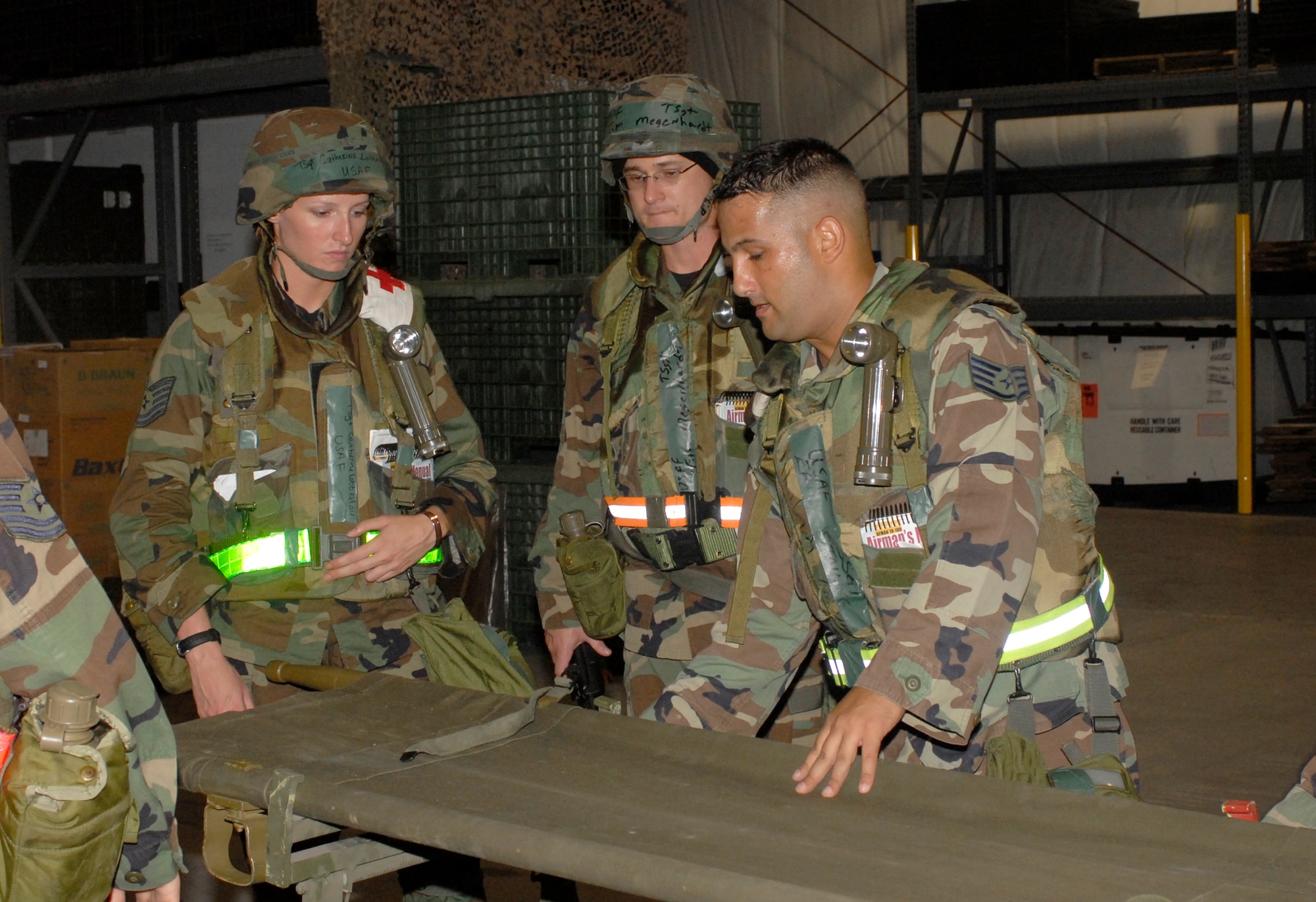 KUNSAN AIR BASE, Republic of Korea -- Staff Sgt. Eric Stailing (right) shows Tech. Sergeants Catherine Lobbestael and Timothy Megenhardt how to use a NATO gurney during the Wolf War Days here July 16. The Airmen are assigned to the 8th Medical Group. The Wolf War Days is a mini exercise designed to familiarize Airmen with exercise procedures.  (U.S. Air Force photo/Staff Sgt. Darcie Ibidapo)