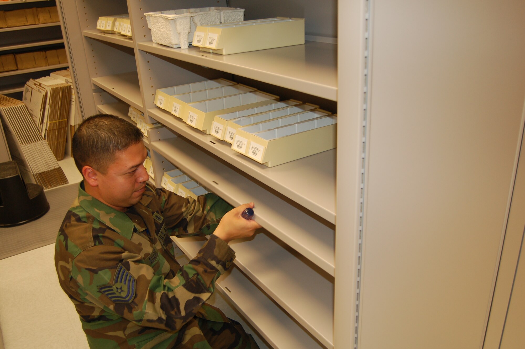 Tech. Sgt. Michael Suarez, 21st Medical Group, adjusts shelving at the new pharmacy at Pete East. The new pharmacy, which opens July 23, has five windows and is much larger than the pharmacy at the old commissary. (U.S. Air Force photo by Corey Dahl)