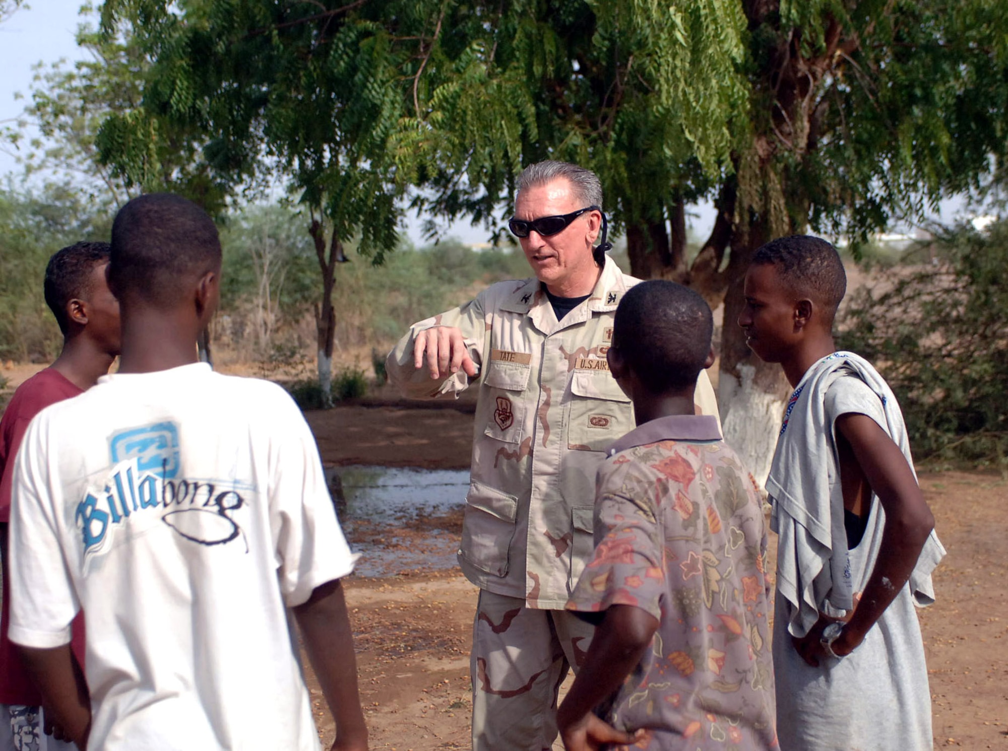 Chaplain (Col.) Gregory Tate talks with teenagers outside of the boys' orphanage July 13 near Camp Lemonier in Djibouti. Chaplain Tate, the U.S. Central Air Forces Command chaplain, visited Djibouti as part of his Central Command area of operation tour, observing Air Force chaplain services and religious support teams. (U.S. Navy photo/Petty Officer 1st Class John Osborne) 
