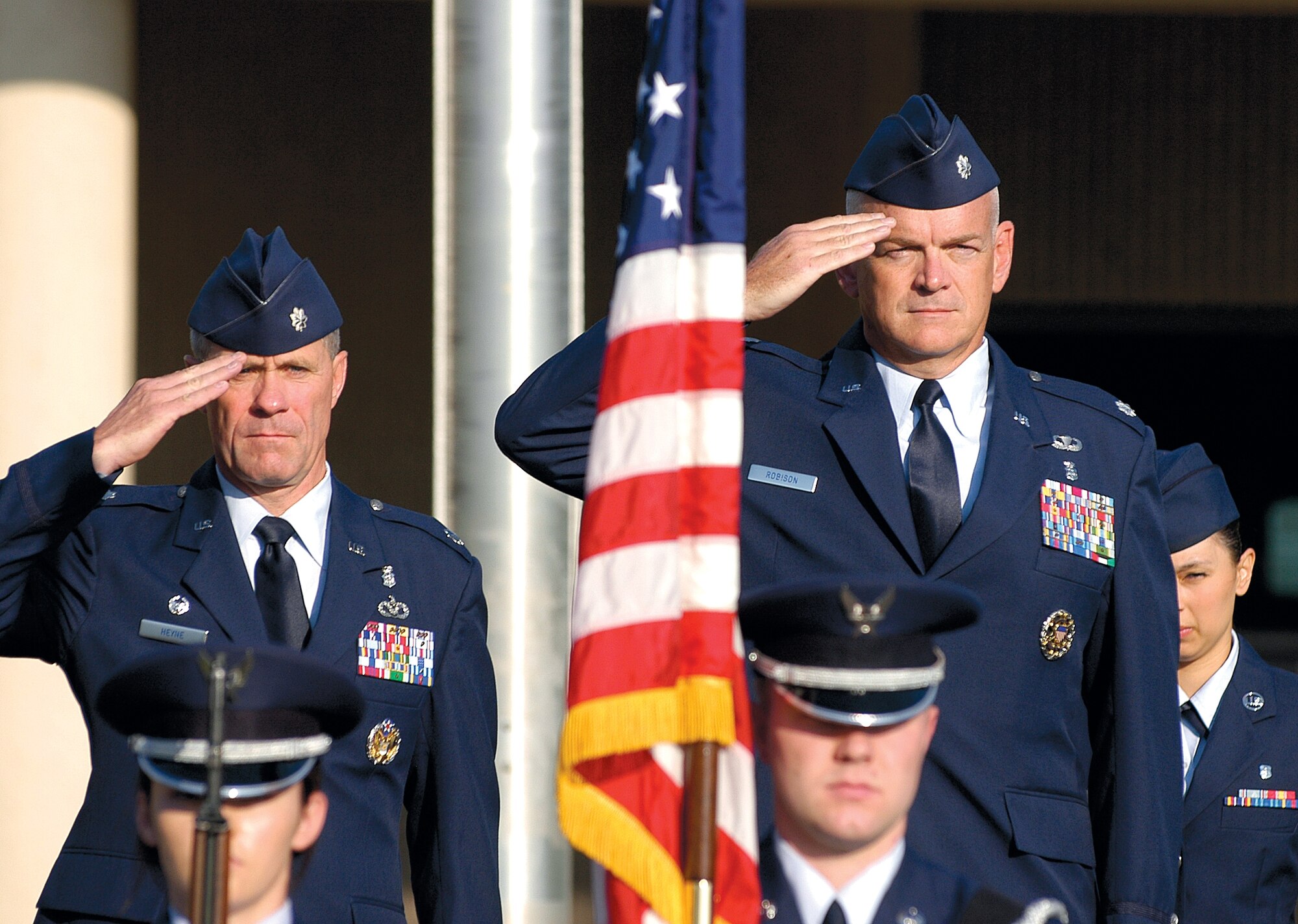As the national anthem plays, outgoing 72nd Medical Support Squadron Commander Lt. Col. Lorn Heyne, left, and incoming commander Lt. Col. Elmo Robison honor the flag during the July 6 change of command ceremony. (Air Force photo by Margo Wright
