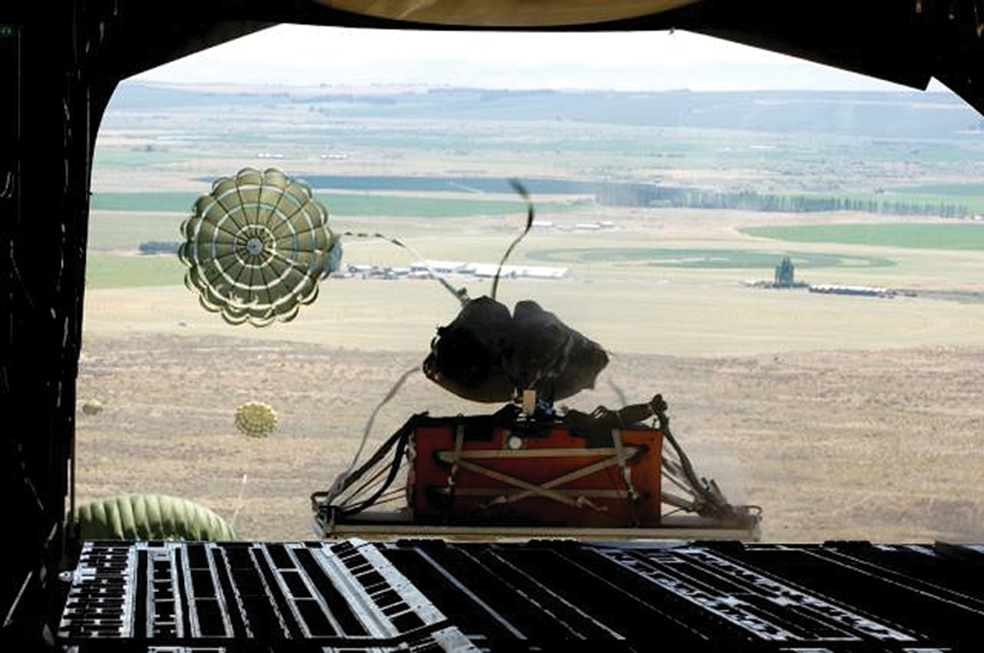 A heavy pallet is airdropped over the Larsen drop zone in Moses Lake, Wash., where reservists fromthe 446th Airlift Wing and active-duty Airmen from the 62nd Airlift Wing, gathered July 10 to fine tune their skills for Air Mobility Command's Rodeo 2007. Both wings are assigned to McChord Air Force Base, Wash. More than 55 U.S. and international teams are slated to participate in AMC's Rodeo 2007 to be held July 22 through 28 at McChord. The competition focuses on readiness, and features airdrop, air refueling, and other events showcasing security forces, aerial port, maintenance and aeromedical evacuation personnel. (U.S. Air Force photo/Abner Guzman)