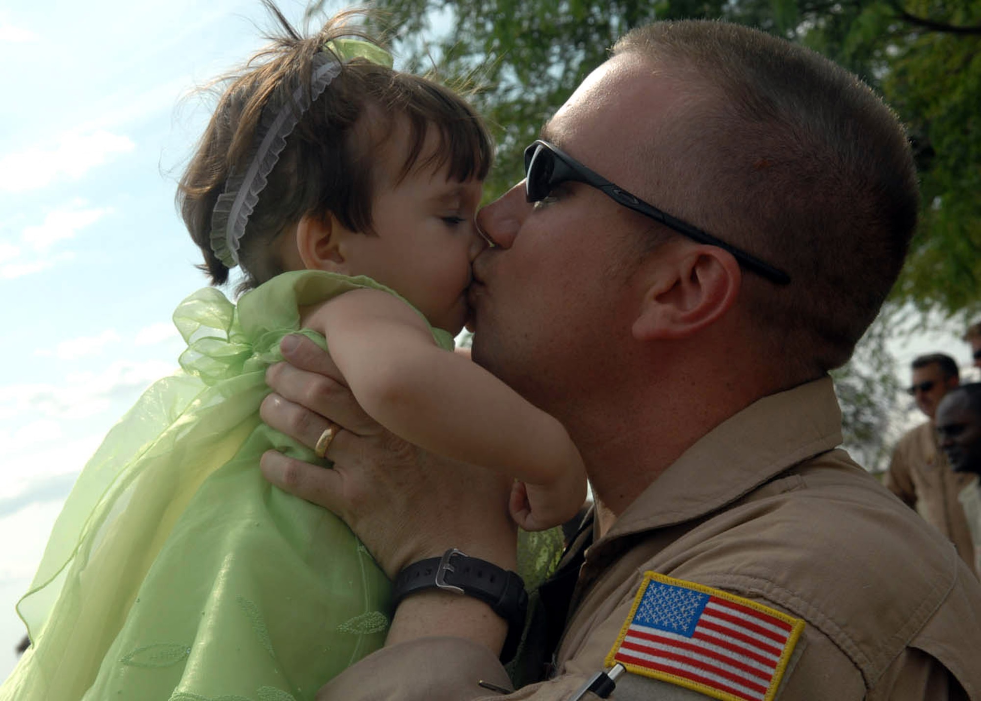 Staff Sgt. Garry Gray kisses his 1-year-old daughter Jessica Denise as they are reunited July 9 after his return from a 120-day deployment to Balad Air Base, Iraq, at Davis-Monthan Air Force Base, Ariz. Sergeant Gray is an aerial gunner assigned to the 55th Rescue Squadron. (U.S. Air Force photo/Senior Airman Christina D. Ponte)