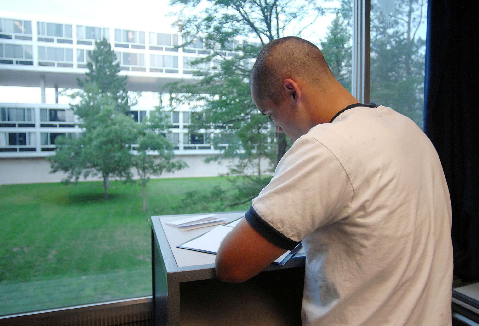 Cadet Steven Michael-Martinez writes a letter home during a brief break before his physical fitness test July 12 at the U.S. Air Force Academy, Colo. The Academy received 9,162 application for this year's class in which only 1,600 were offered appointments. These first-year cadets receive basic discipline and skills to help develop them into officers. (U.S. Air Force photo/Tech. Sgt. Larry A. Simmons)
