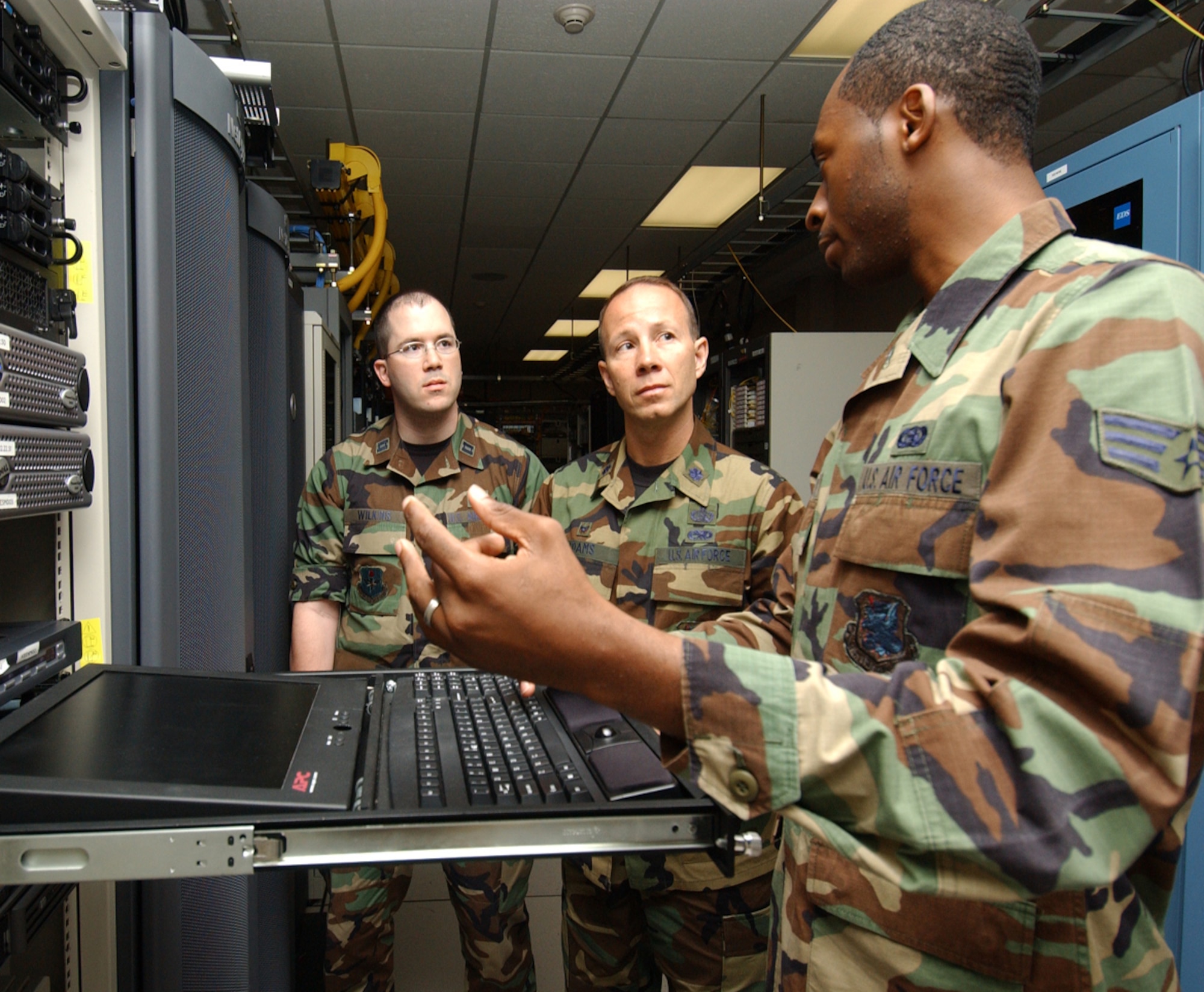 From left, Capt. John Wilkins and  Lt. Col. Ray Adams Jr., new commander of the 81st Communications Squadron, are briefed by Senior Airman Taveres Simpson on the system management server.  Colonel Adams took command July 2.  He comes to Keesler  from Scott Air Force Base, Ill., where he was U.S. Transportation Command’s  test and transformation branch chief in the  command, control, communications and computer systems directorate.   (U.S. Air Force photo by Kemberly Groue)