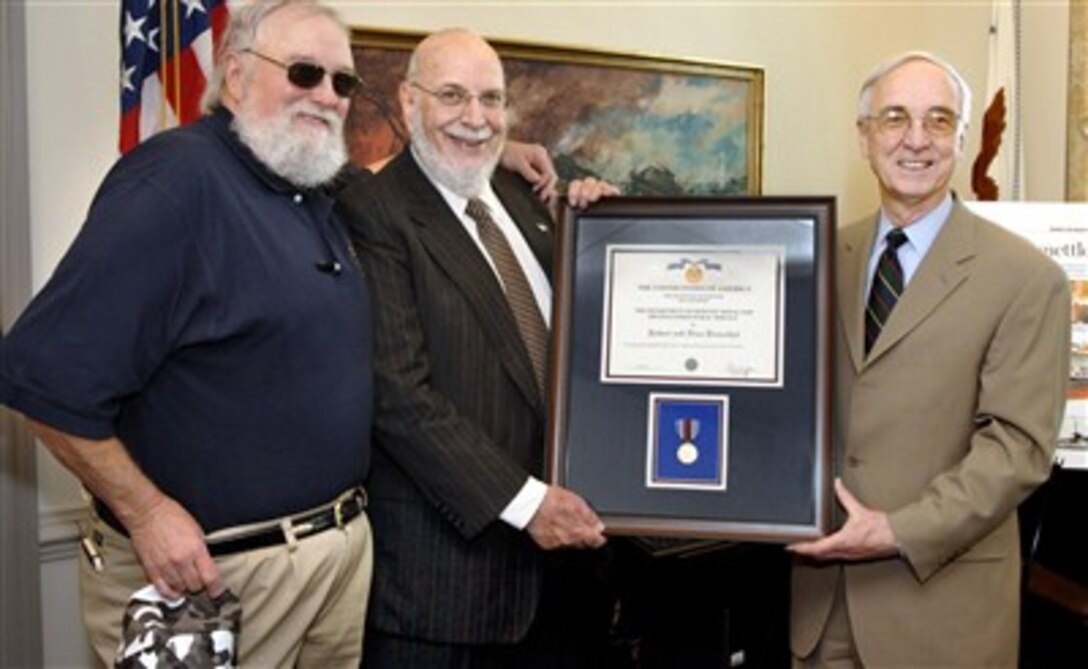 Deputy Defense Secretary Gordon England (right) presents the Department of Defense Medal for Distinguished Public Service to Robert Rosenthal (center), founder of the "Spirit of America Tour," which brings entertainers to military installations around the nation.  Singer Charlie Daniels, of the Charlie Daniels Band -- one of the groups involved in the "Spirit of America Tour," also participated.  