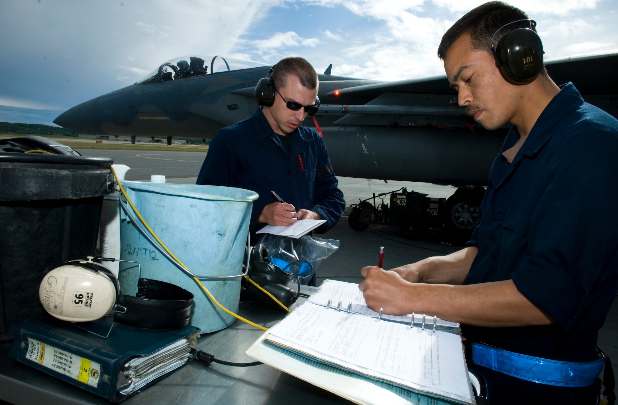 Staff Sgt. Mark Curtis (left) and Staff Sgt. Mark Allen (right) fill out maintenance forms before launching an F-15C. Sergeants Curtis and Allen are assigned to the 19th Aircraft Maintenance Unit. (U.S. Air Force photo by Senior Airman Garrett Hothan)