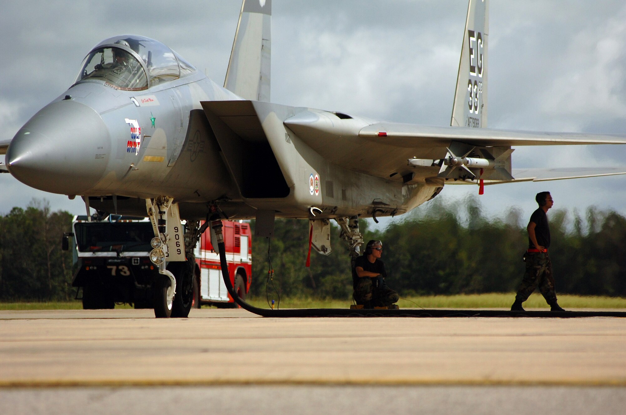 Crew chiefs from the 60th Aircraft Maintenance Unit stay in the shade while an F-15C Eagle refuels during surge operations July 17 at Eglin Air Force Base, Fla. During surge operations, flying takes place throughout the day from early morning to dusk. Surges are used to help the wing simulate wartime flying. The intensified flying also benefits the wing in all facets of training. The 33d Fighter Wing is conducting surge operations July 17 through July 19. During a normal surge, 15-20 jets will take off, fly a mission, land and refuel then take off again in rapid rotation up to three times. Up to 100 sorties in a day's time may be flown. (U.S. Air Force photo by Staff Sgt. Bryan Franks)
