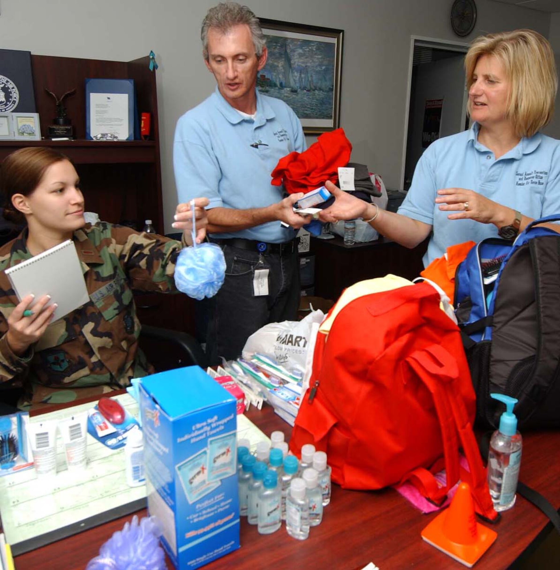 From left, Lieutenant Lutz, Mr. Newman and Ms. Waters sort through some of the donations.  (U.S. Air Force photo by Kemberly Groue)