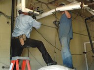 MINOT AIR FORCE BASE, N.D. -- Construction workers prepare a utility room at the Shoppette here for installation of a boiler. Minot Air Force Base has begun the process of deactivating its central heat plant and installing individual boilers in 92 buildings across the base in a move to save money and conserve natural gas. (U.S. Air Force photo by Airman 1st Class Wesley Wright)