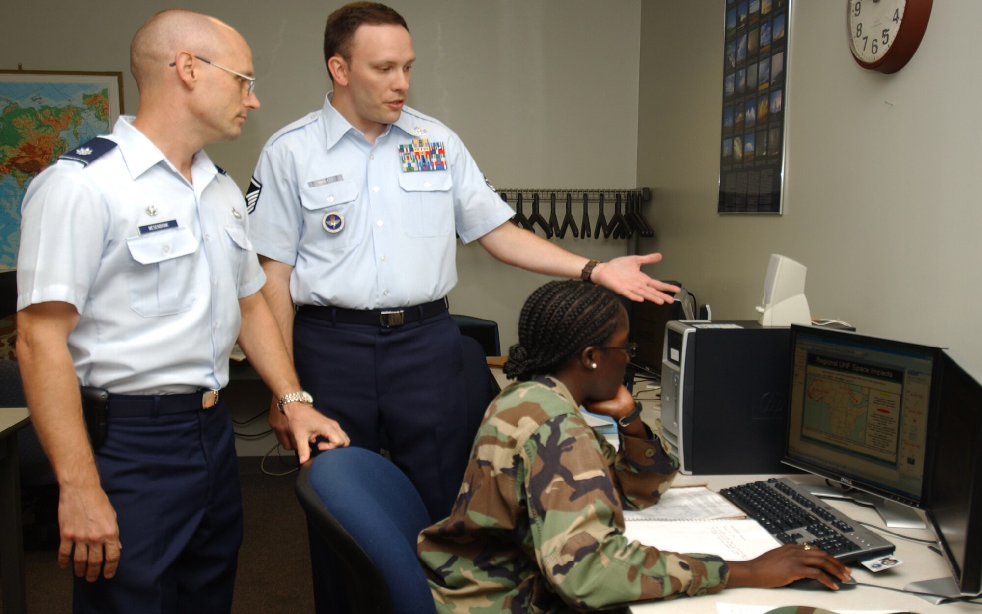 Lt. Col. Mark Mesenbrink, left, 335th Training Squadron commander, is briefed by  Master Sgt. Robert Marlett, 335th TRS instructor supervisor, on the combat weather team operations course.  The student is 1st Lt. Martine Morris.  Colonel Mesenbrink took command of the 335th TRS from Lt. Col. Elia Sanjume July 12.  (U.S. Air Force photo by Kemberly Groue)