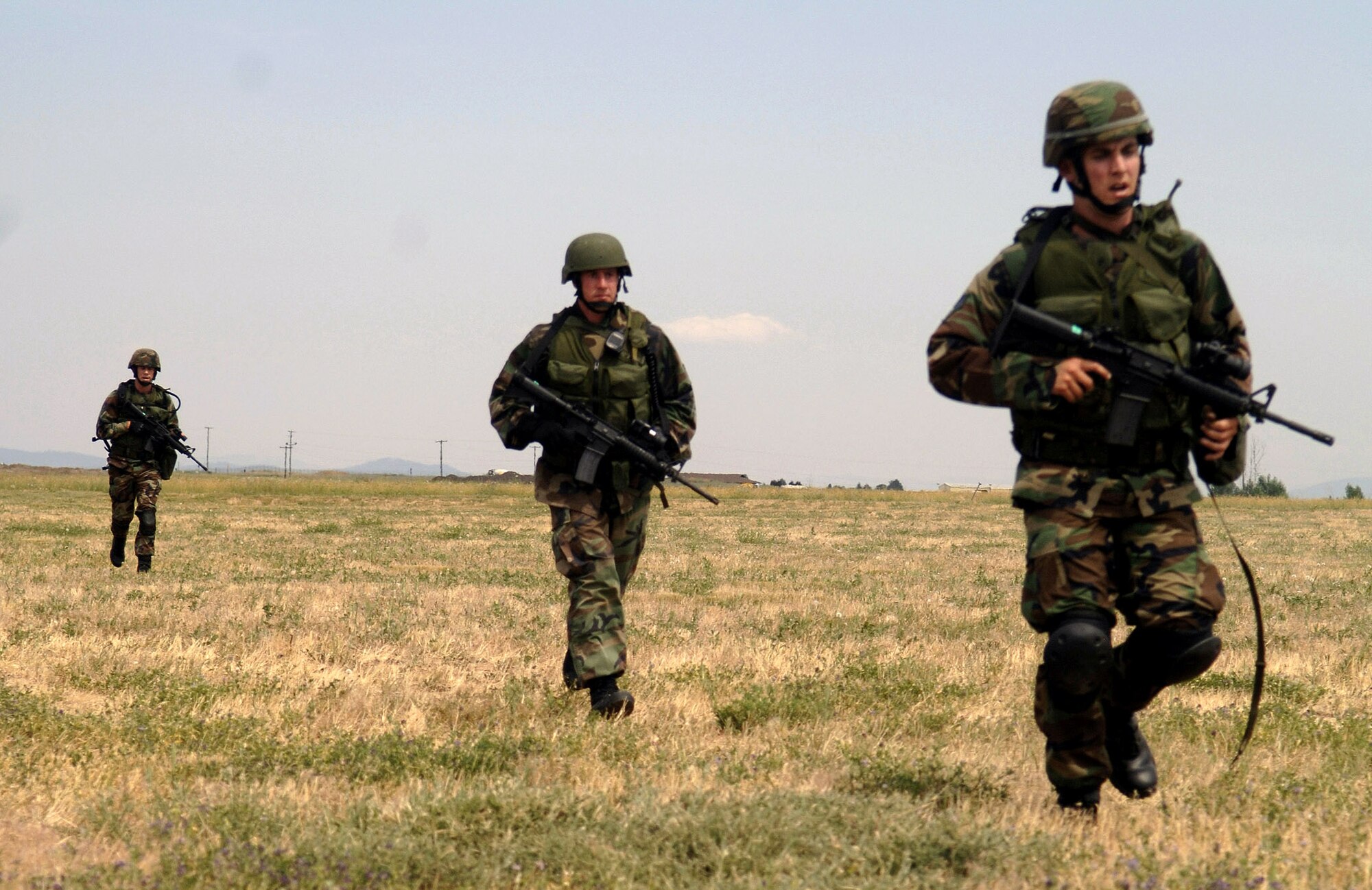 Senior Airman David Jones, Staff Sgt. Levi Wilson and Senior Airman Lonnie Bell march to the next checkpoint in a practice training course July 13 at Fairchild Air Force Base, Wash. The three-Airman team is training for the Air Mobility Command Rodeo 2007 at McChord AFB, Wash., being held at the end of July. (U.S. Air Force photo/Senior Airman Chad Watkins) 
