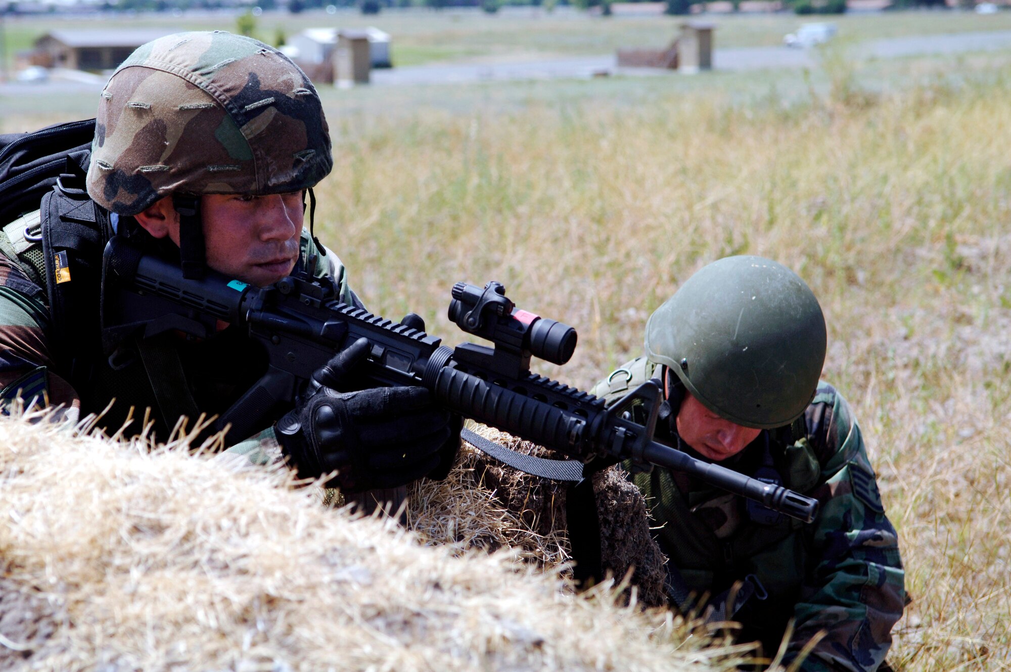 Senior Airman Lonnie Bell watches for enemy forces while Staff Sgt. Levi Wilson documents coordinates on a map during a practice session July 13 at Fairchild Air Force Base, Wash. The Airmen are training for the Air Mobility Command Rodeo 2007 at McChord AFB, Wash., being held at the end of July. (U.S. Air Force photo/Senior Airman Chad Watkins) 