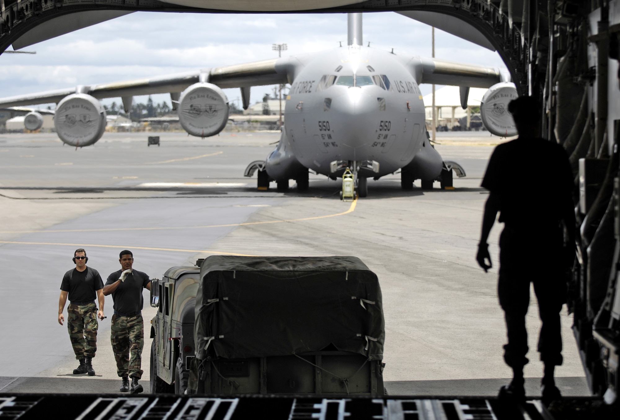 HICKAM AIR FORCE BASE, Hawaii -- Rodeo team members guide a Humvee onto a C-17 Globemaster III here July 13. Members from the 535th Airlift Squadron and 15th Logistics Readiness Squadron, Combat Mobility Element are practicing for upcoming Air Mobility Command Rodeo at McChord Air Force Base, Wash. (U.S. Air Force photo/Tech. Sgt. Shane A. Cuomo)