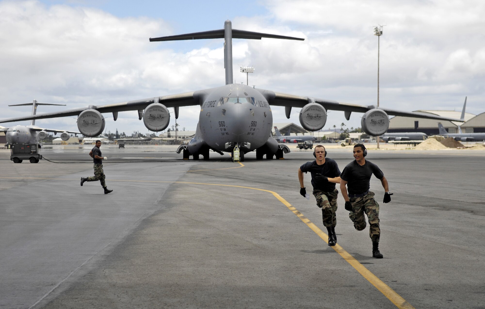 HICKAM AIR FORCE BASE, Hawaii -- Rodeo team members sprint towards a C-17 Globemaster III during a rodeo practice here July 13. Members from the 535th Airlift Squadron and 15th Logistics Readiness Squadron, Combat Mobility Element are practicing for upcoming Air Mobility Command Rodeo at Air Force Base, Wash. (U.S. Air Force photo/Tech. Sgt. Shane A. Cuomo)