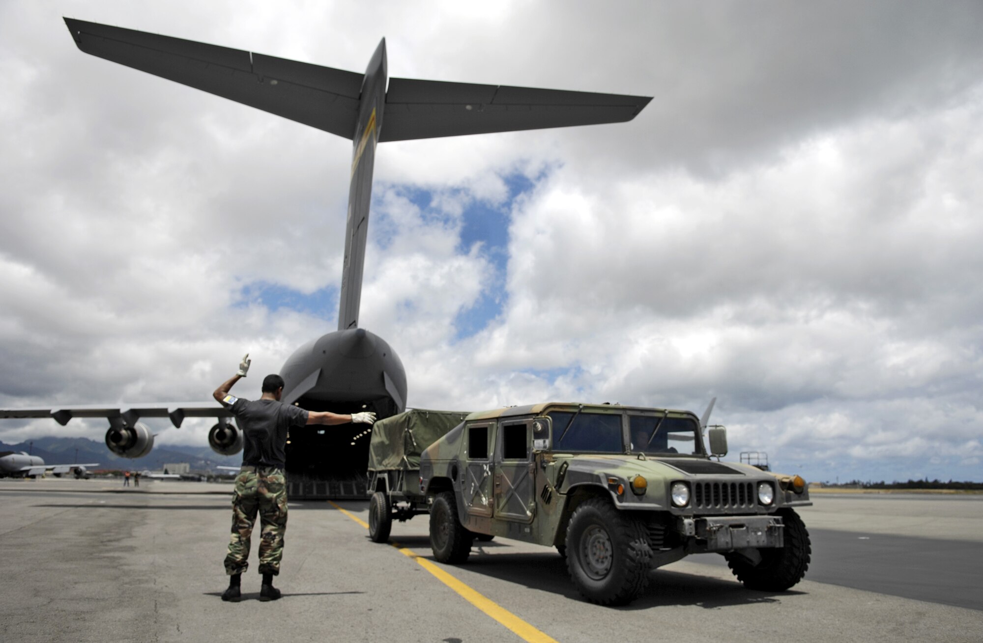 HICKAM AIR FORCE BASE, Hawaii -- Master Sgt. Greg Martinez guides a Humvee off of a C-17 Globemaster III here July 13 during a rodeo practice.  Sergeant Martinez is from the 15th Logistics Readiness Squadron, Combat Mobility Element and is part of Hickam’s Rodeo team. The team is practicing for the upcoming Air Mobility Command Rodeo at McChord Air Force Base, Wash. (U.S. Air Force photo/Tech. Sgt. Shane A. Cuomo)