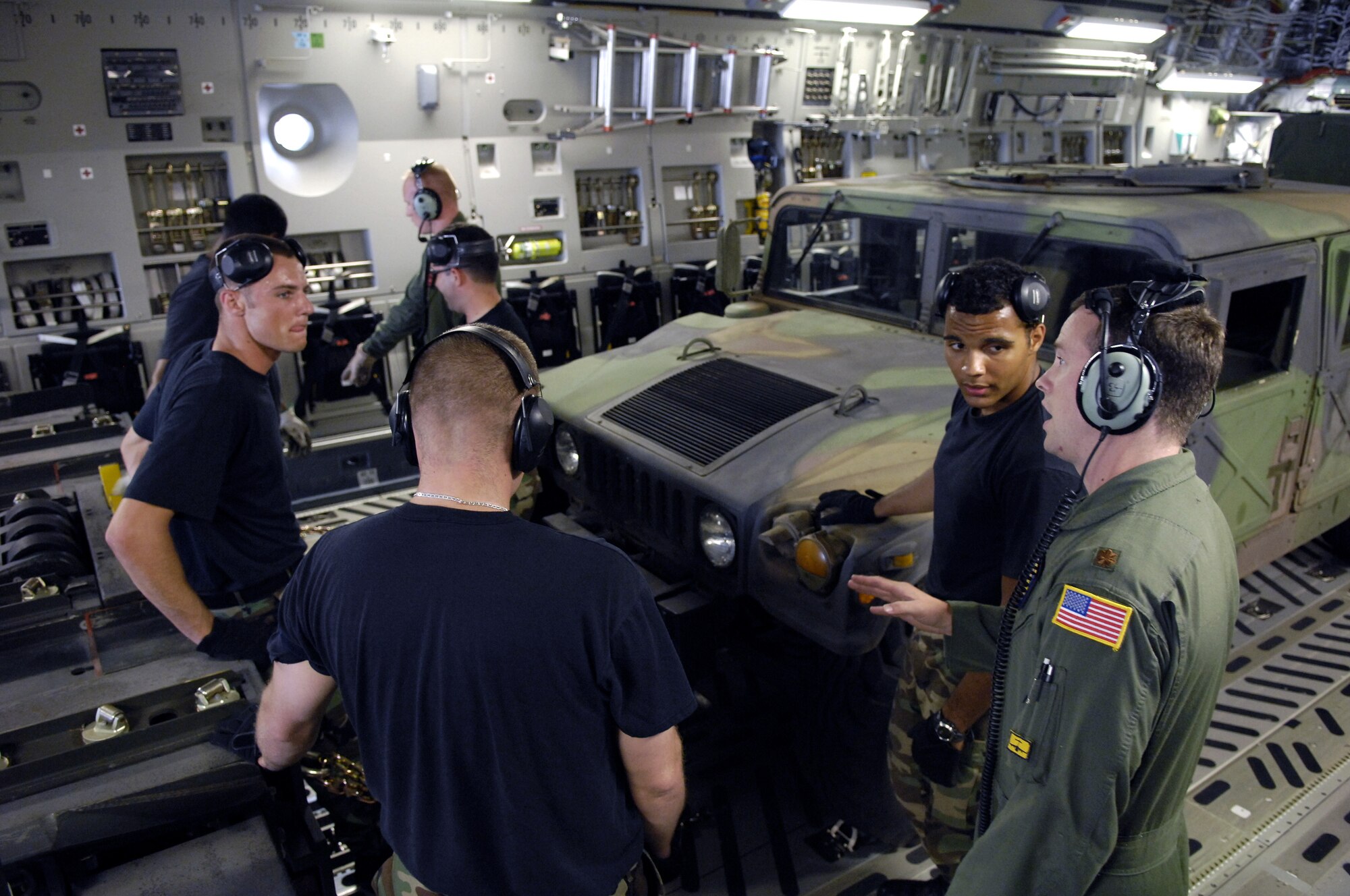 HICKAM AIR FORCE BASE, Hawaii -- Rodeo team members discuss techniques on loading equipment onto a C-17 Globemaster III here July 13. Members from the 535th Airlift Squadron and 15th Logistics Readiness Squadron, Combat Mobility Element are practicing for upcoming Air Mobility Command Rodeo at McChord Air Force Base, Wash. (U.S. Air Force photo/Tech. Sgt. Shane A. Cuomo)