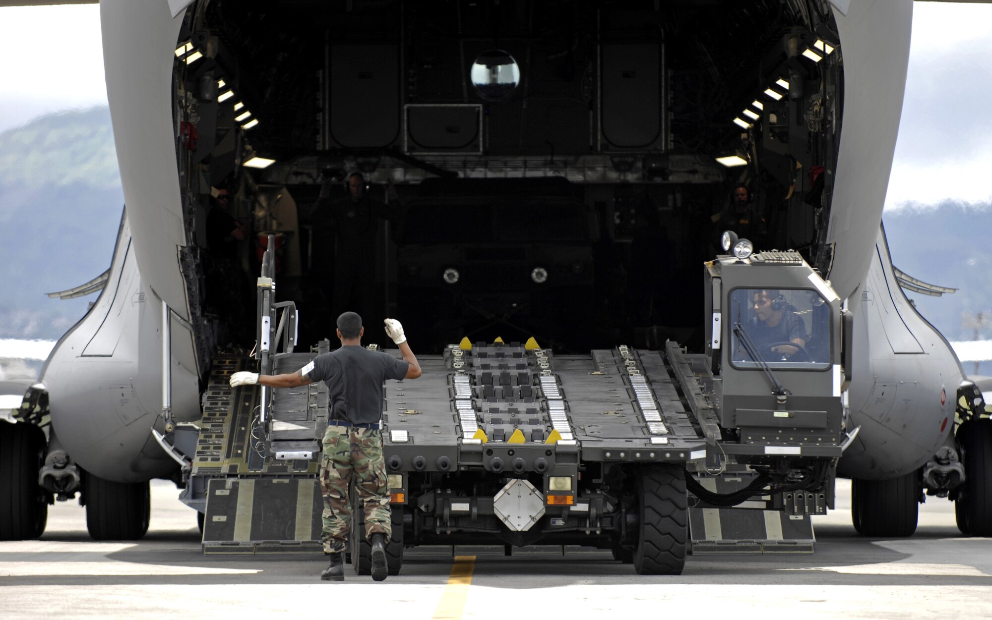 HICKAM AIR FORCE BASE, Hawaii -- Master Sgt. Greg Martinez guides a K-loader onto a C-17 Globemaster III here July 13during a rodeo practice. Sergeant Martinez is from the 15th Logistics Readiness Squadron, Combat Mobility Element and is part of Hickam’s Rodeo team. The team is practicing for the upcoming Air Mobility Command Rodeo at McChord Air Force Base, Wash. (U.S. Air Force photo/Tech. Sgt. Shane A. Cuomo)