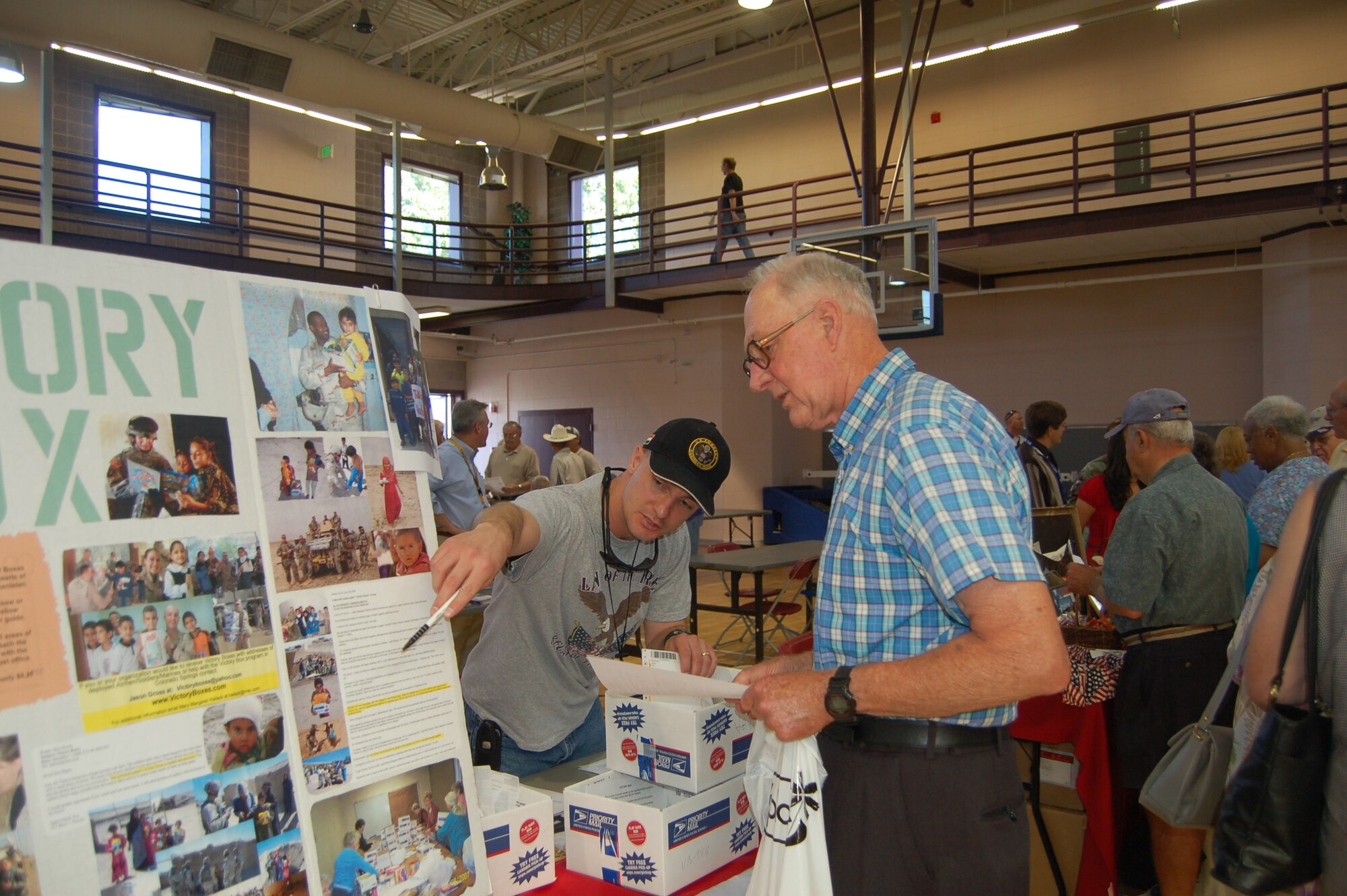 Maj. Jason Gross, Air Force Space Command, explains the Victory Box program to a retiree July 14 at the Retiree Appreciation Day information fair. Topics included medical facilities, the new pharmacy and commissary grand opening, and the temporary closure of the West Gate. (U.S. Air Force photo by Corey Dahl)