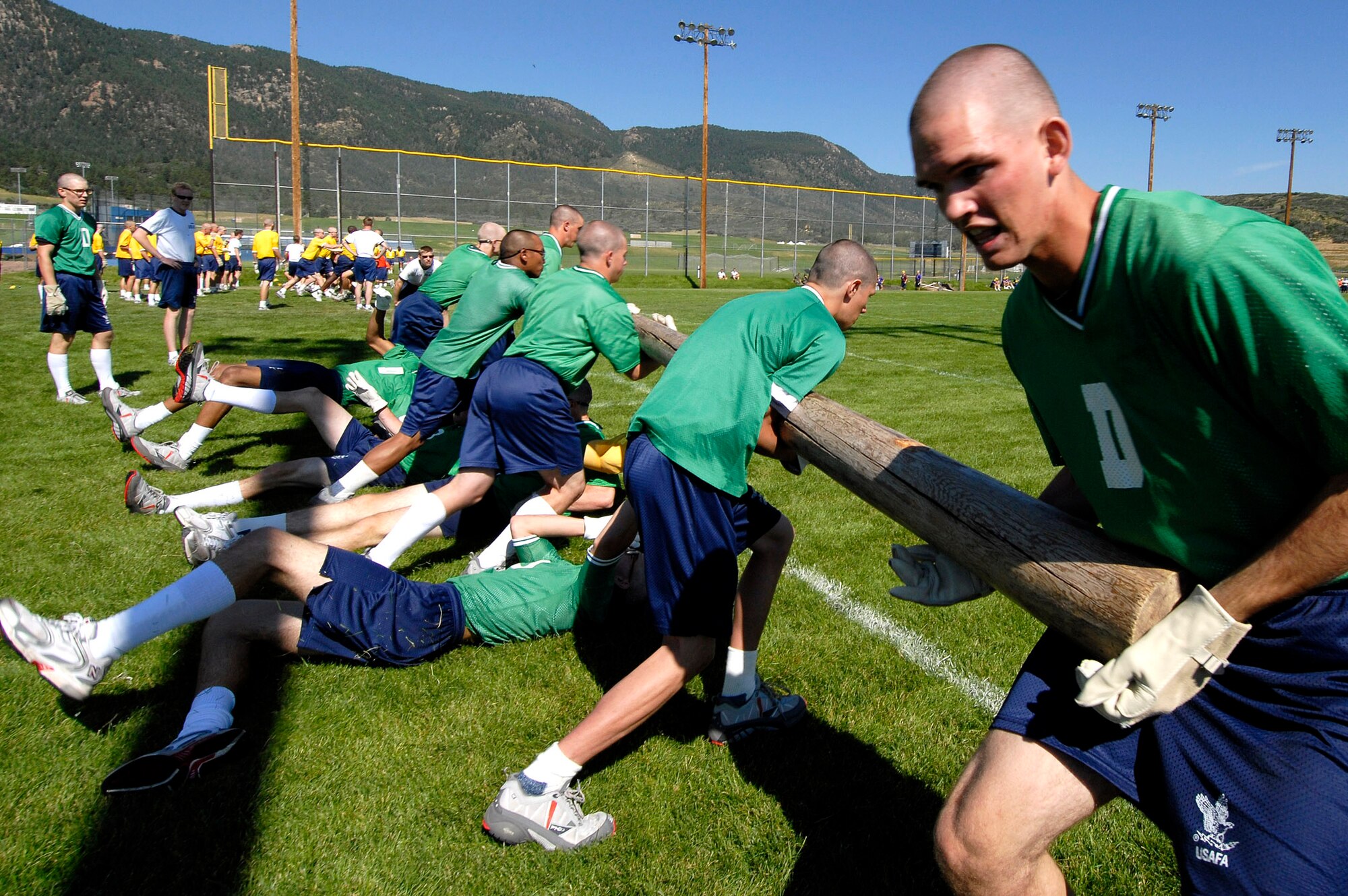 The transfer of the pole takes perfect timing as basic cadet trainees slide under the pole as a new team takes over during the pole carry event July 14 at U.S. Air Force Academy in Colorado. New cadets are in their first month of training at the Academy and are learning honor, discipline and integrity in addition to physical fitness. (U.S. Air Force photo/Mike Kaplan)

