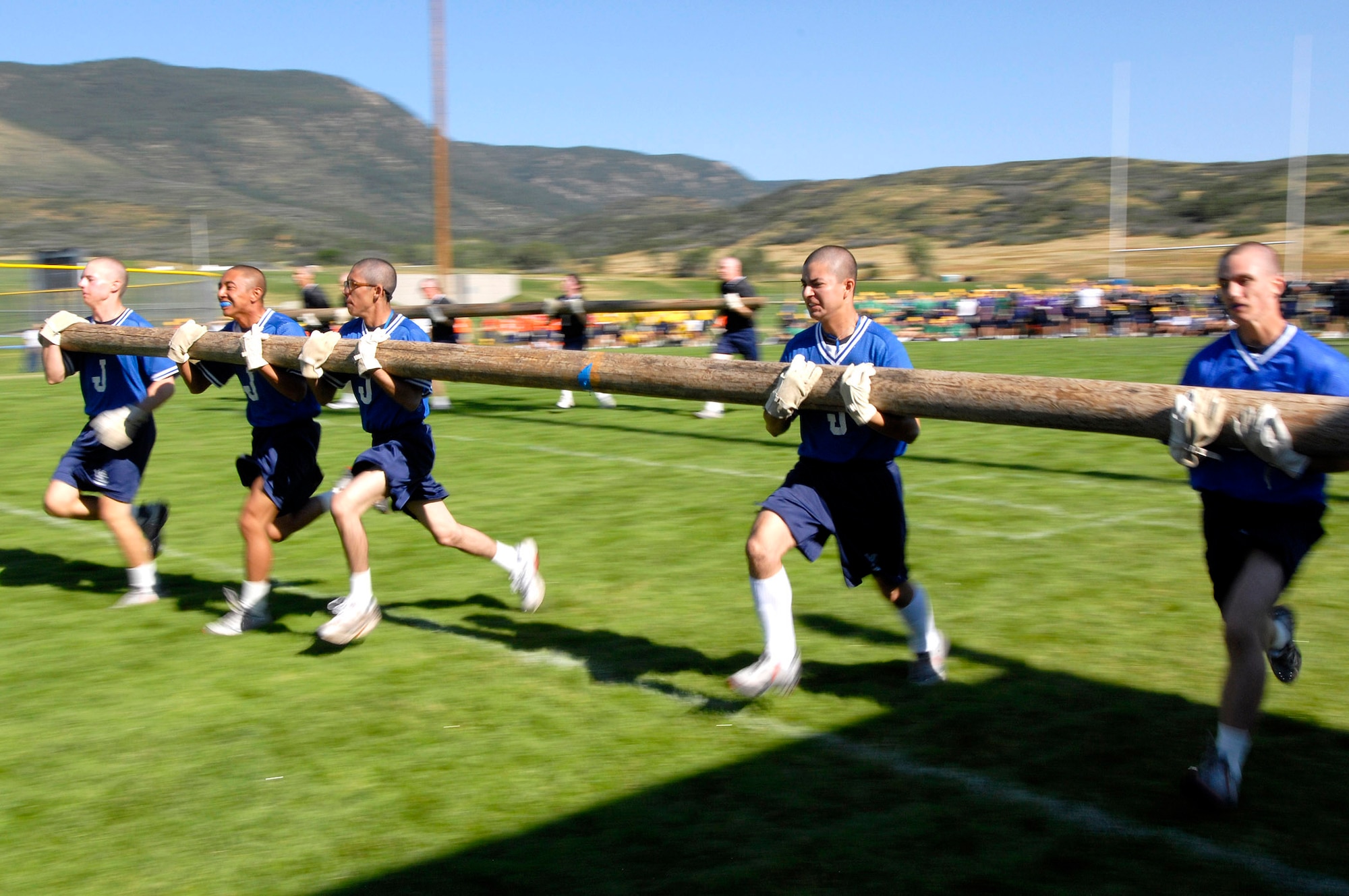 A team of basic cadet trainees strain as they sprint across the field in the pole-carry event during Field Day July 14 at the U.S. Air Force Academy in Colorado. New cadets are in their first month of training at the Academy and are learning honor, discipline and integrity in addition to physical fitness. (U.S. Air Force photo/Mike Kaplan) 
