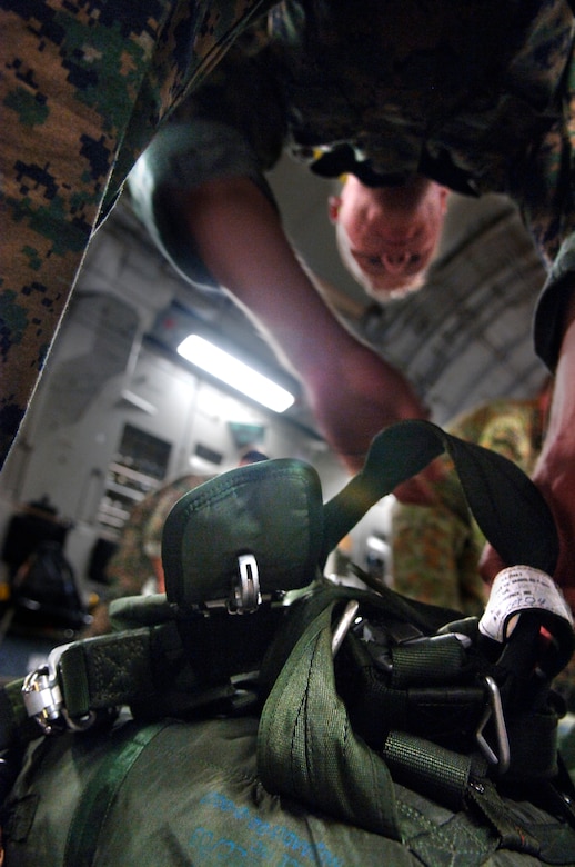 U.S. Marine Corps Cpl. Austin Mitchell-Briggs, a parachute rigger in the 2nd Air Delivery Unit out of Camp Lejeune, N.C., prepares to don his parachute for a joint service airdrop training exercise July 12, 2007 at Charleston AFB, S.C. (U.S. Air Force Photo/Airman 1st Class Nicholas Pilch)