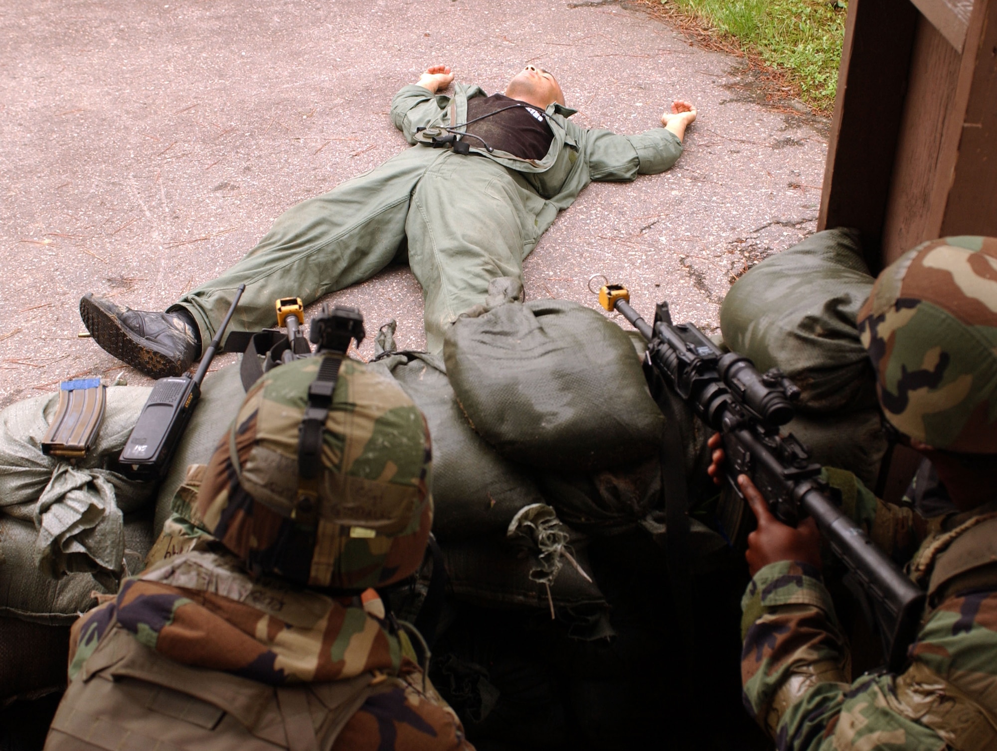 KUNSAN AIR BASE, Republic of Korea -- Staff Sgt. Richard Gonzales (left) and Senior Airman Escott Solomon, 8th Security Forces Squadron defenders, secure a defensive fighting position after "taking" down Staff Sgt. Vincent Reed during Wolf War Days on July 17. Sergeant Reed was role playing opposing forces during the training scenario where security forces Airmen responded to opposing forces on the base. (U.S. Air Force Photo/Senior Airman Steven R. Doty)                            