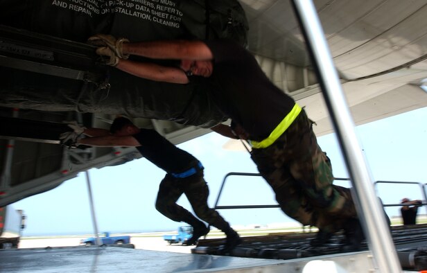Staff Sgts. James Cantu, Lance Schutts and Alejandro Castillo, from the 733rd Air Mobility Squadron, push a heavy piece of cargo onto an L-100 civilian aircraft at Kadena Air Base, Japan, July 19. The plane travels to Osan AB, Korea; Yokota, AB, Misawa AB and Kadena three times a week delivering and picking up equipment.
U.S. Air Force photo/Staff Sgt. Reynaldo Ramon
