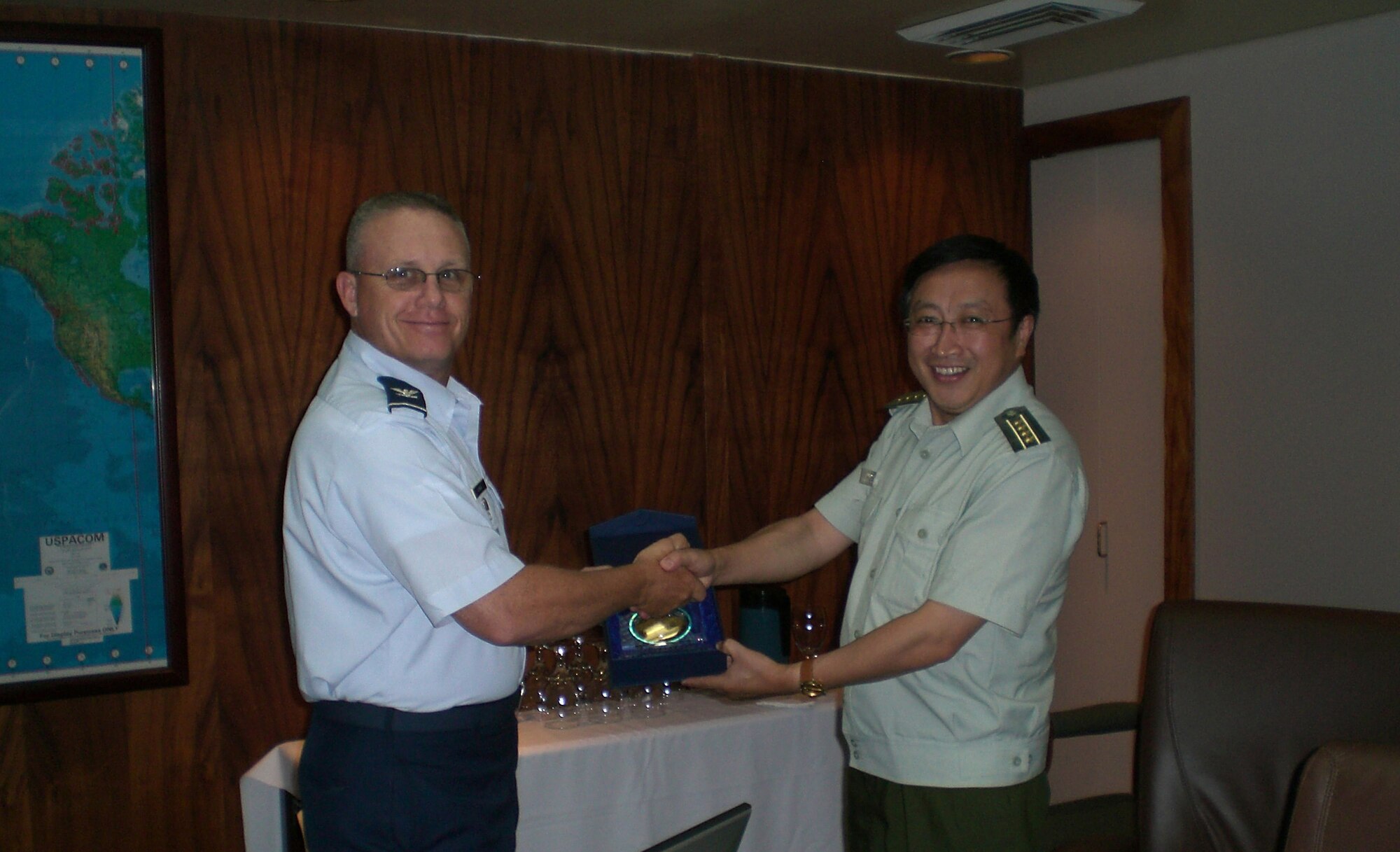 HICKAM AIR FORCE BASE, Hawaii -- Col. Daniel Wyman, command surgeon of Pacific Air Forces, exchanges gifts with  Sen. Col. Liu, Jiucheng, deputy director of the Epidemic Prevention Bureau, medical service department, general logistics department of the Chinese People's Liberation Army here July 12. A six-member Chinese delegation from medical fields shared their knowledge and experiences with PACAF during a visit to various components under U.S. Pacific Command July 9-13.