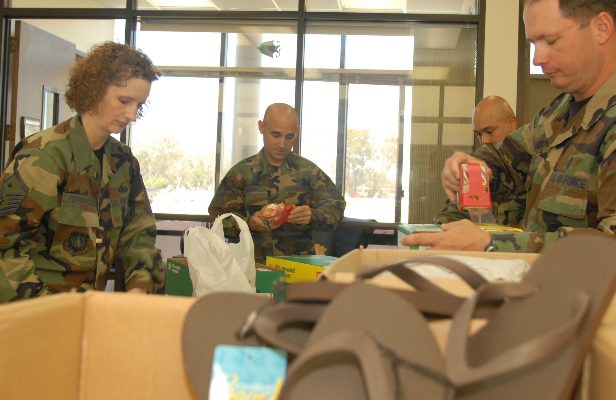 VANDENBERG AIR FORCE BASE, Calif. - Master Sgt. Angela Fernandez, 1st Sgt. for the 30th Medical Group, along with Master Sgt. Mark Guerin, 1st Sgt. for the 30th Logistic Readiness Squadron, and Master Sgt. Michael Jones, 1st Sgt. for the 30th Civil Engineering Squadron, prepare boxes on July 19 to be shipped to Iraq, part of Operation Warrior Comfort at the Logistic Readiness Squadron's Building. Operation Warrior Comfort provides support for the Contingency Air Staging Facility, or CSAF, that cares for sick and wounded Airmen and Soldiers transiting through on their way to Germany for care. The donations that have been fundraised through Operation Warrior Comfort will  provide some of the wounded troops with clothes since most of them arrive to the CASF with nothing but the clothes on their backs. (U.S. Air Force Photo by Senior Airman Kristi Emler)