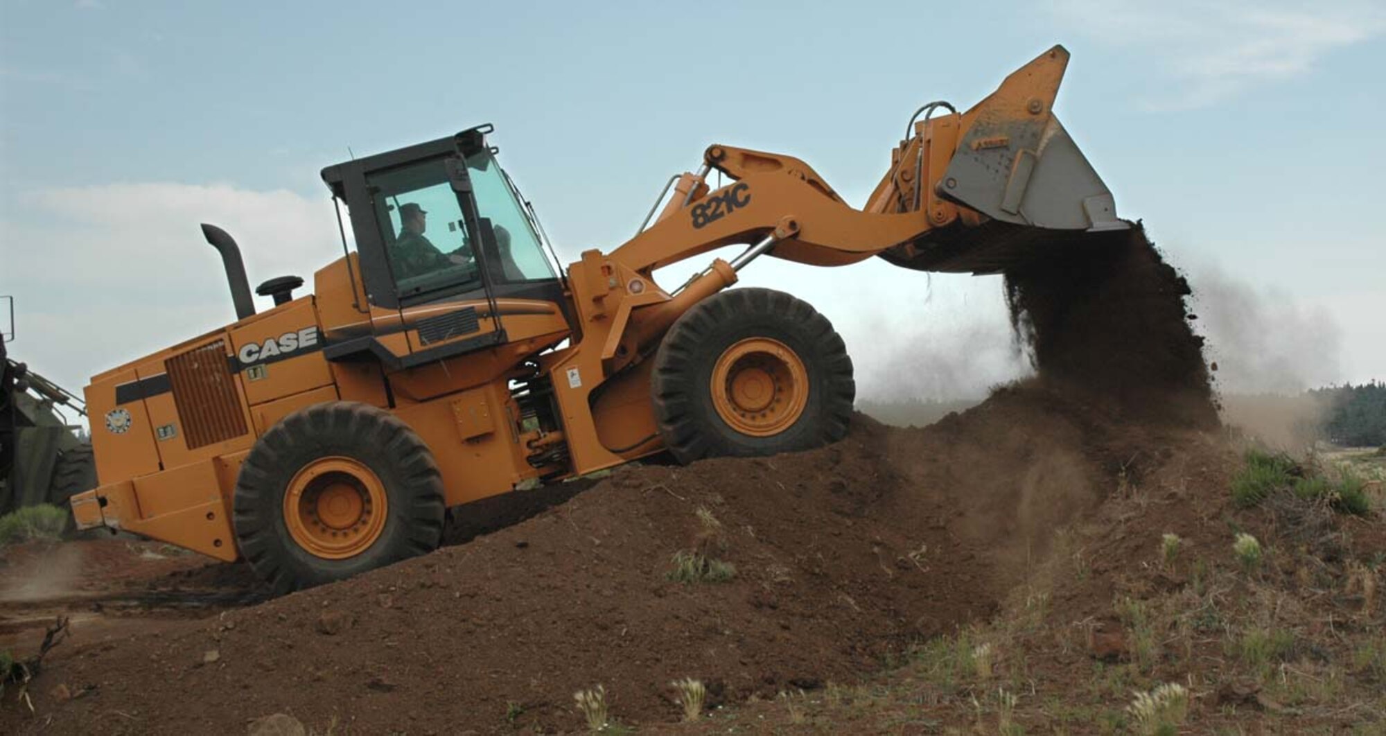 Tech. Sgt. Warren Bert, 944th Civil Engineer Squadron heavy equipment NCO in charge, provides erosion control with a front end loader at Camp Navajo. More than 15 of the 944th CES personnel deployed for a week in July to assist with electrical wiring, plumbing, heater repair, and heavy equipment operations to help maintain more than 2.3 million square feet of storage and warehouse space near Flagstaff, Ariz.  (U.S. Air Force photo/Staff Sgt. Steve Razo)