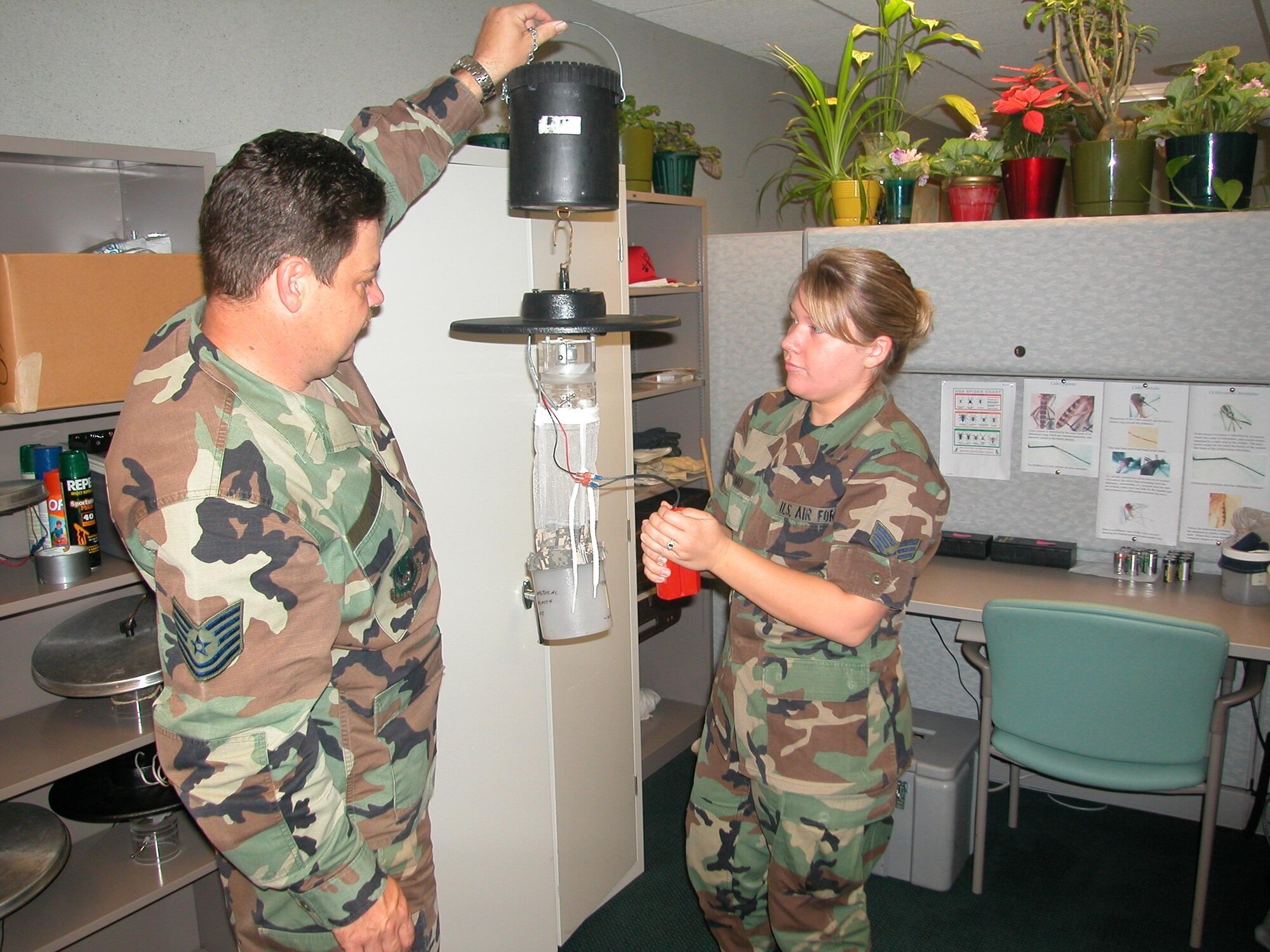 Tech. Sgt. Jeffrey Joy and Senior Airman Katie Romo, both 72nd Aerospace Medicine Squadron public health technicians, set up a mosquito trap. The trap works by emitting carbon dioxide, which attract the mosquito, then a fan sucks the mosquito into the trap. (Air Force photo by Kandis West)