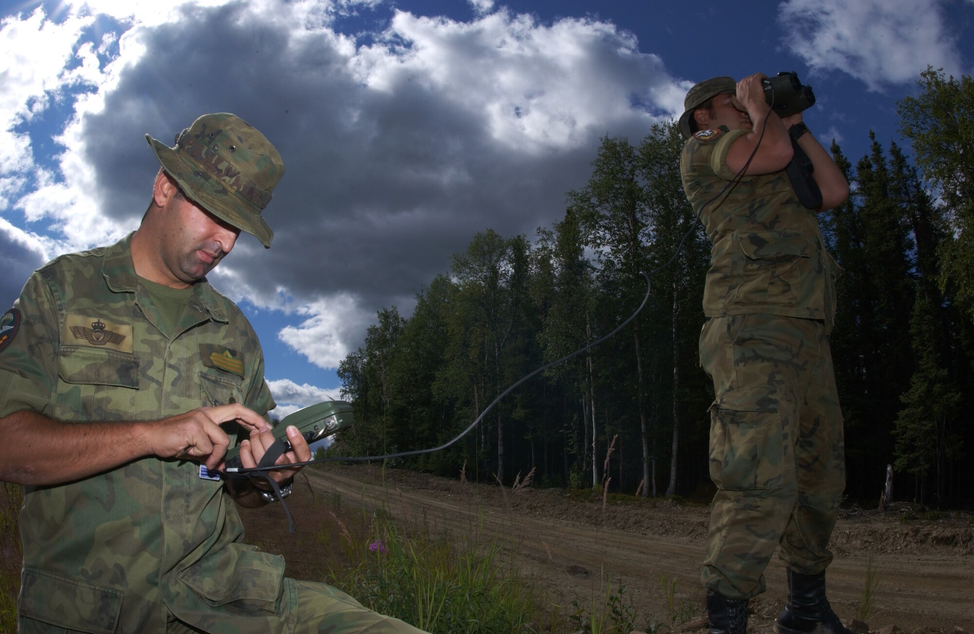 EIELSON AIR FORCE BASE, Alaska -- Senior Airman Victor Martinez (Left) and Airman Basic Hugo Lesta (Right), Spanish Air Force, Tactical Air Control Party, uses a range finder and GPS unit to mark the target location and relay that information to the pilots on the Pacific Alaskan Range Complex on July 16 during Red Flag-Alaska 07-3. The PARC provides 67,000 square miles of airspace, one conventional bombing range and two tactical bombing ranges containing more than 400 different types of targets and more than 30 threat simulators which allows them to exchange tactics, techniques, and procedures and improve interoperability. (U.S. Air Force Photo by Airman 1st Class Jonathan Snyder)