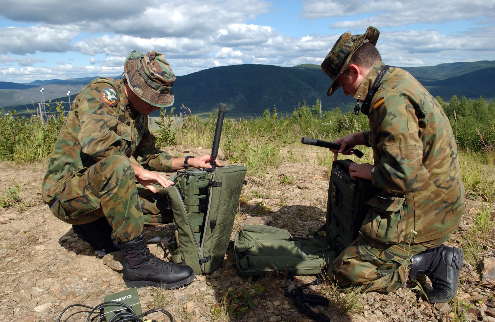 EIELSON AIR FORCE BASE, Alaska -- Airman 1st Class Diego Figuerua (Left) and Senior Airman Francisco Infiesta (Right), Spanish Air Force, Tactical Air Control Party, set up a PRC-117 multiband radio to communicate to the aircrafts on the Pacific Alaskan Range Complex on July 16 during Red Flag-Alaska 07-3. The PARC provides 67,000 square miles of airspace, one conventional bombing range and two tactical bombing ranges containing more than 400 different types of targets and more than 30 threat simulators which allows them to exchange tactics, techniques, and procedures and improve interoperability. (U.S. Air Force Photo by Airman 1st Class Jonathan Snyder) 