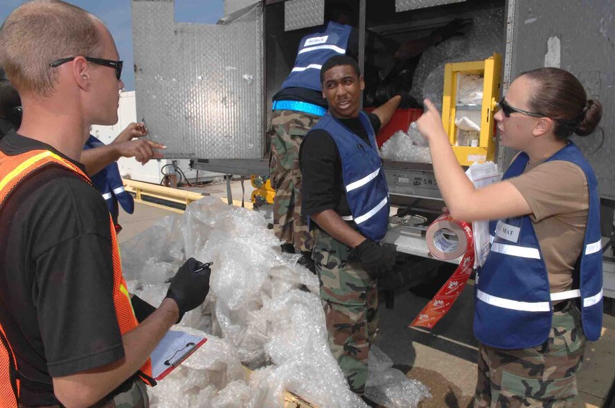 SHAW AIR FORCE BASE, S.C.-- Staff Sgt. Steven Jackson (left), 20th Aircraft Maintenance Squadron support technician, acts as a cargo liaison for the aircraft maintenance equipment while Staff Sgt. Johanna Achey (right), 20th Logistics Readiness Squadron hazardous material inspector, inspects all cargo for hazmat. Staff Sgt. Dommonic Bland (center), 20th Component Maintenance Squadron, calculates, measures and weighs cargo for processing during an operational readiness exercise July 16. Operational readiness exercises help prepare Airmen for predeployment scenarios for future contingencies. (U.S. Air Force photo/Airman 1st Class Matthew Davis)