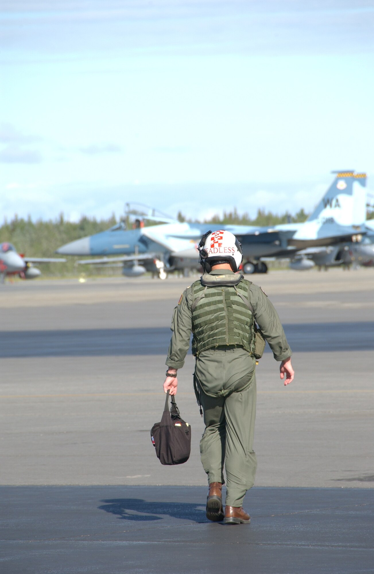 EIELSON AIR FORCE BASE, Alaska -- A Navy Pilot walks out to his aircraft as an F-15 Aggressor taxis down the runway July 16, 2007. This exercise provides unique opportunities to help integrate various forces into joint, coalition, and bilateral training from simulated forward operating bases. (U.S. Air Force photo by Airman 1st Class Christopher Griffin) 